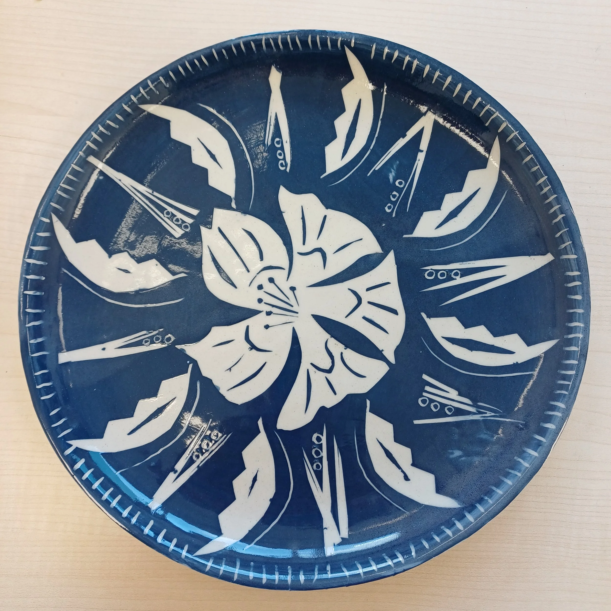 Blue circular plate with a white butterfly and floral design.