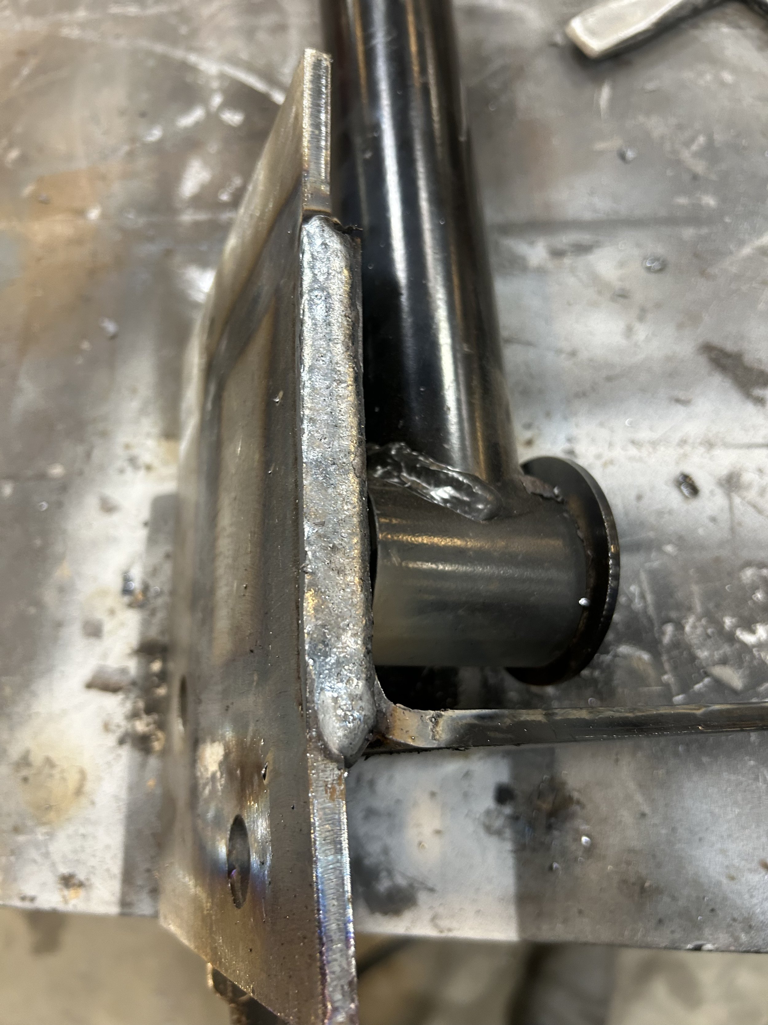 Close-up view of a metal welding process with a weld bead on the joint between two metal parts.