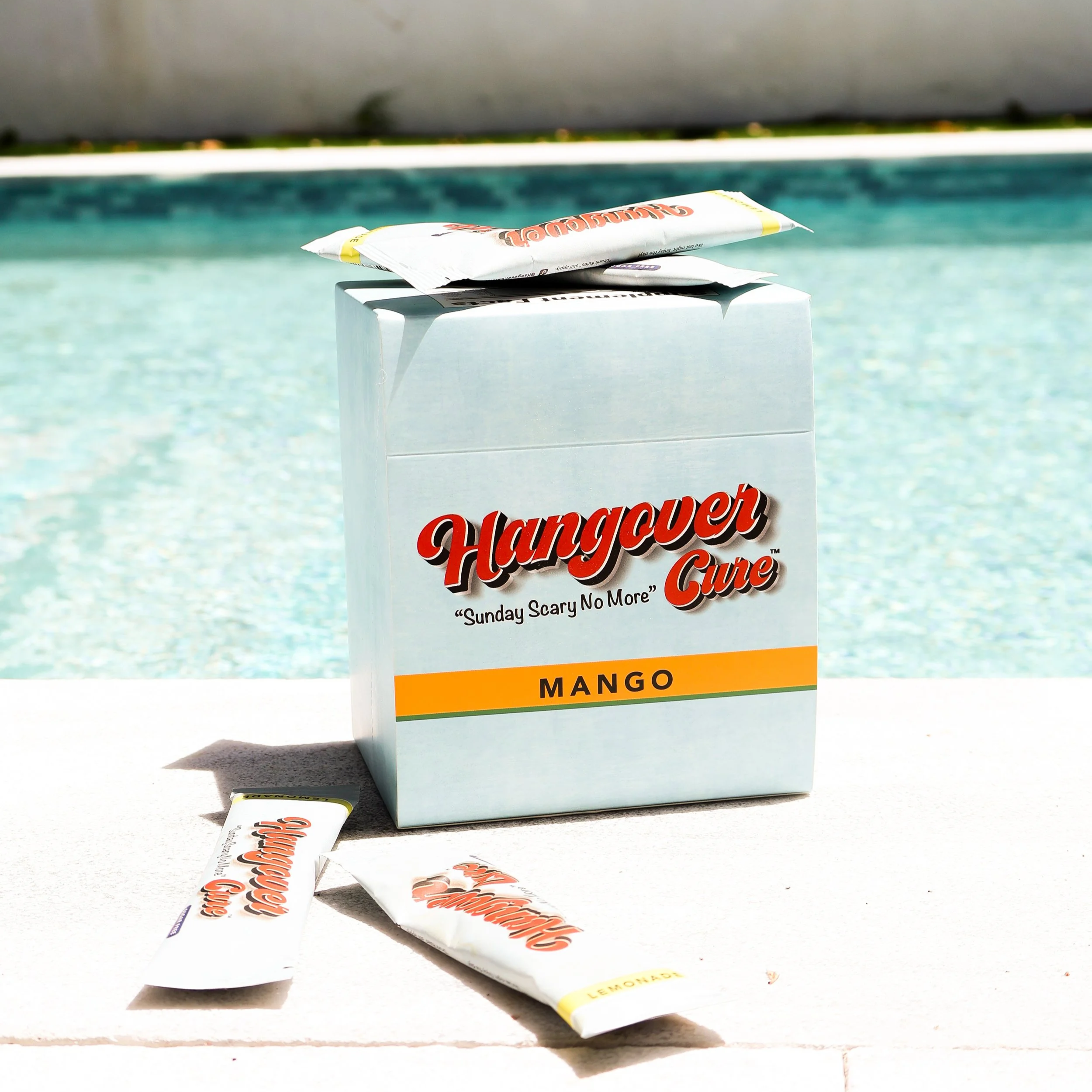 Box of warning cure chewing gum with two discarded gum wrappers on a white surface.