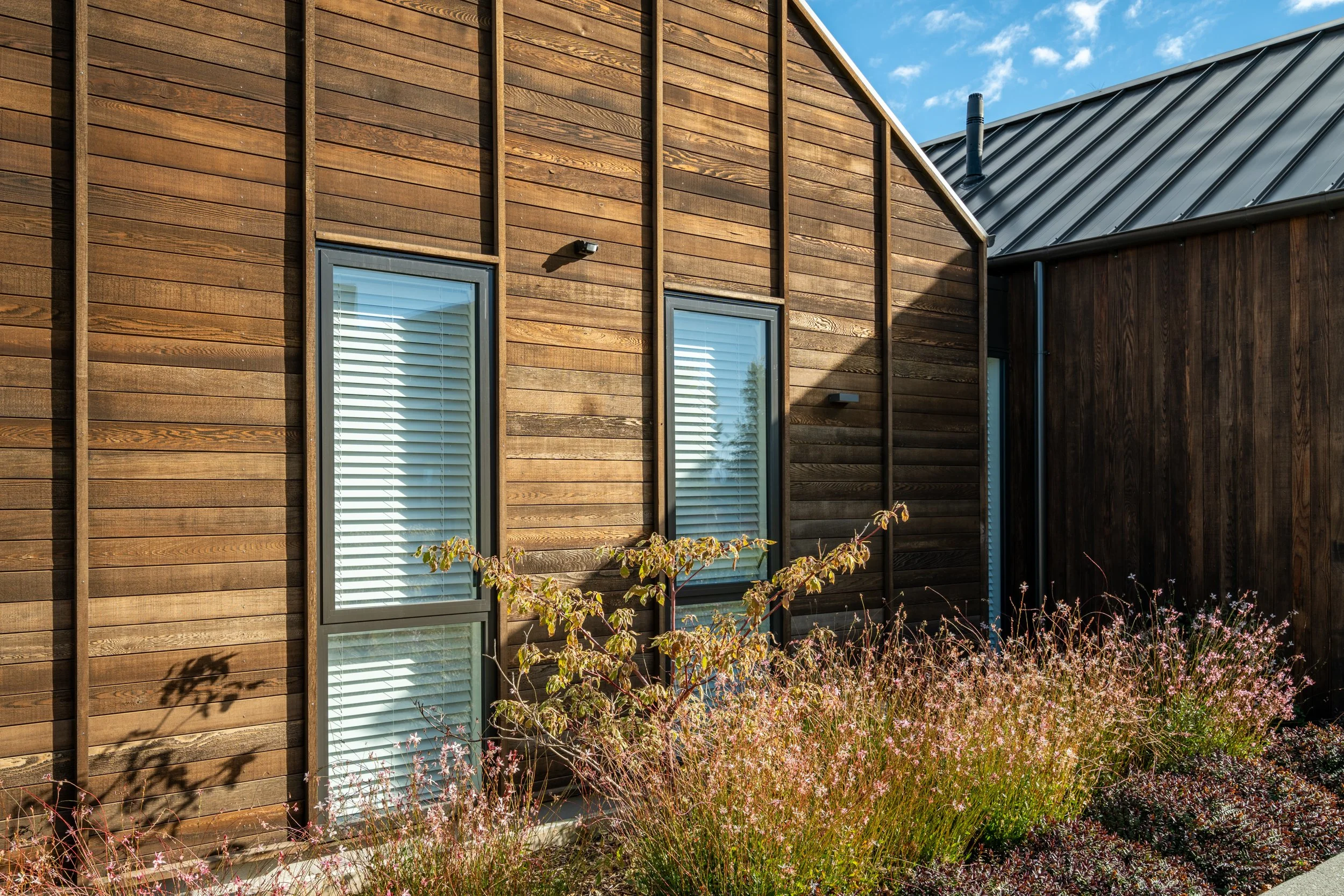 Close-up of dark stained timber cladding and refined exterior detailing at Alpine Residence.