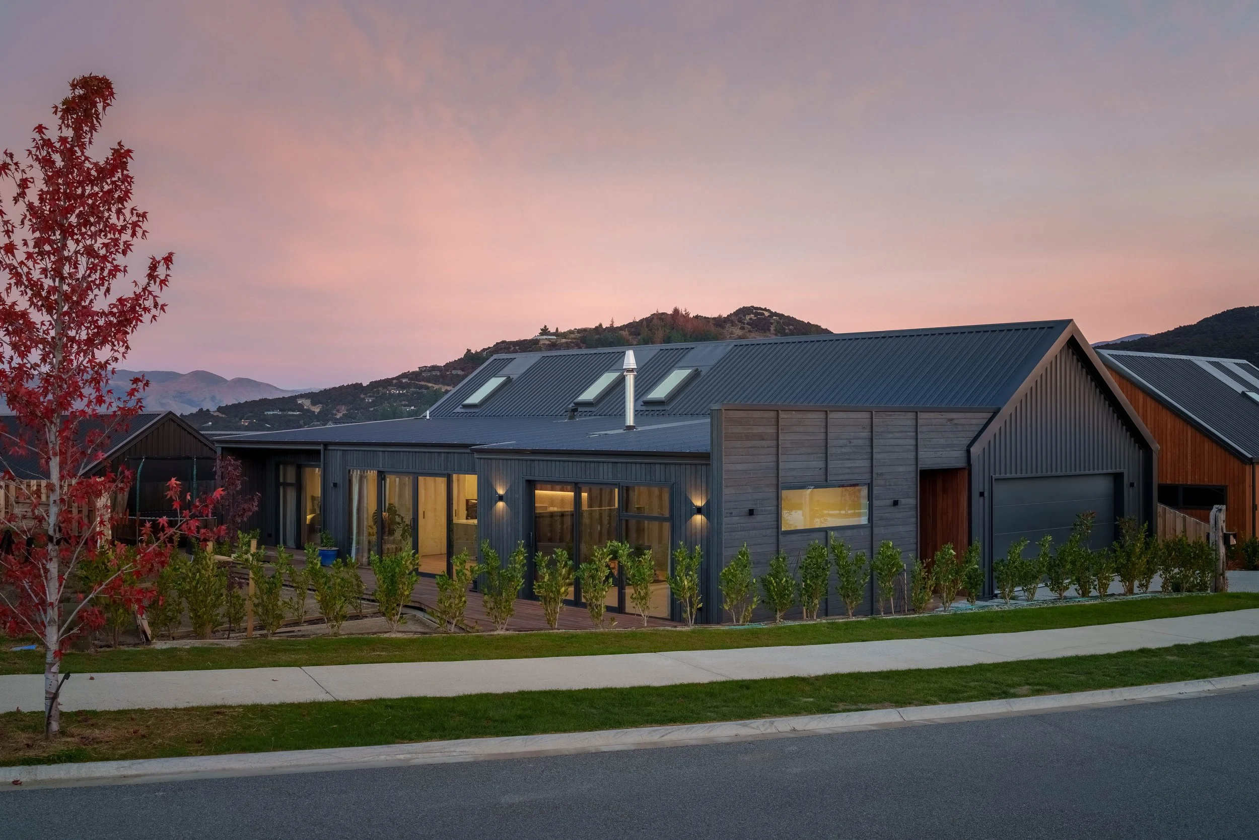 Northlake Residence II is a contemporary Wānaka home designed with bespoke, reclaimed vertical cladding, warm lighting, and strong alpine-inspired forms.