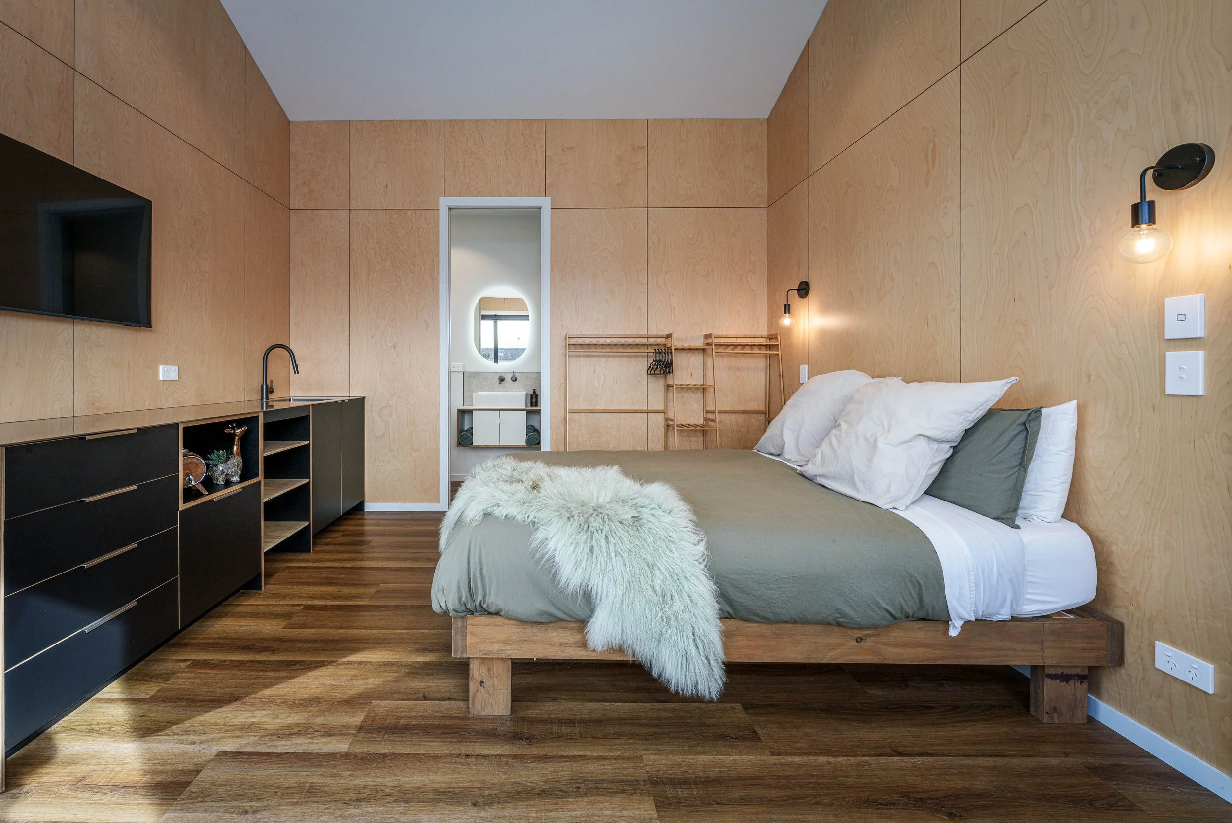 Warm plywood lining and minimalist detailing create a calm, functional studio retreat.