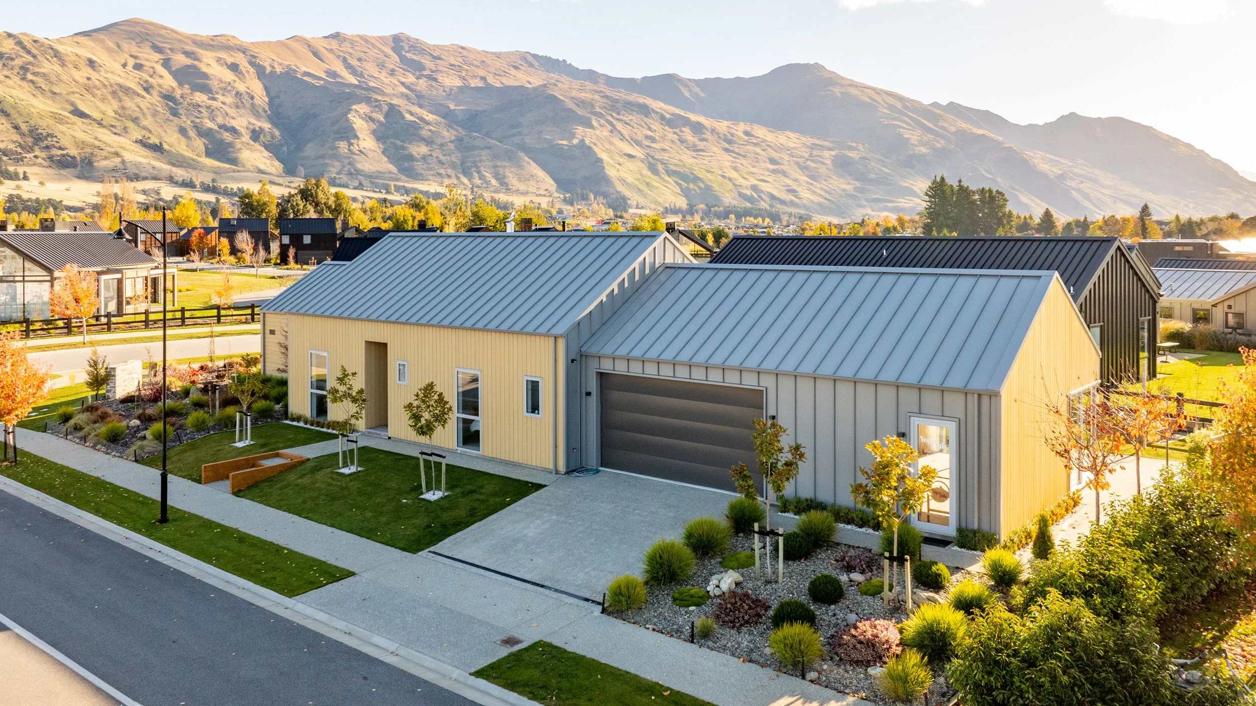 Contemporary exterior of Marjon Residence with gable rooflines and landscaped grounds against the Wānaka mountains.