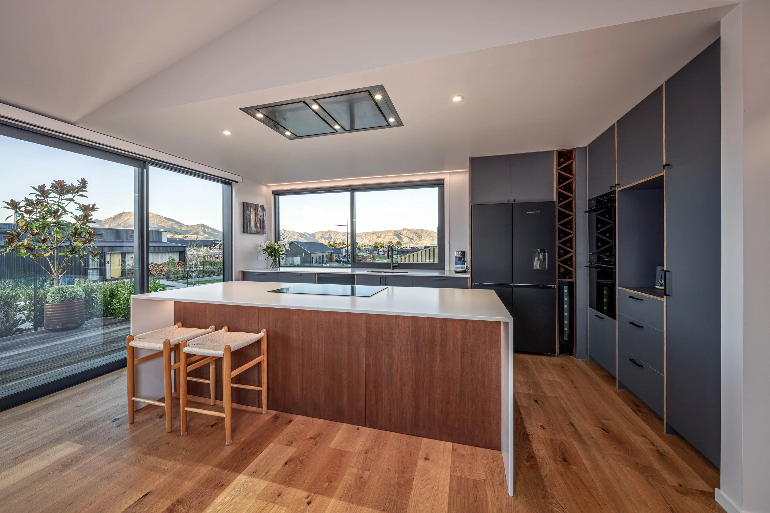Open-plan kitchen with custom cabinetry and expansive mountain views. 