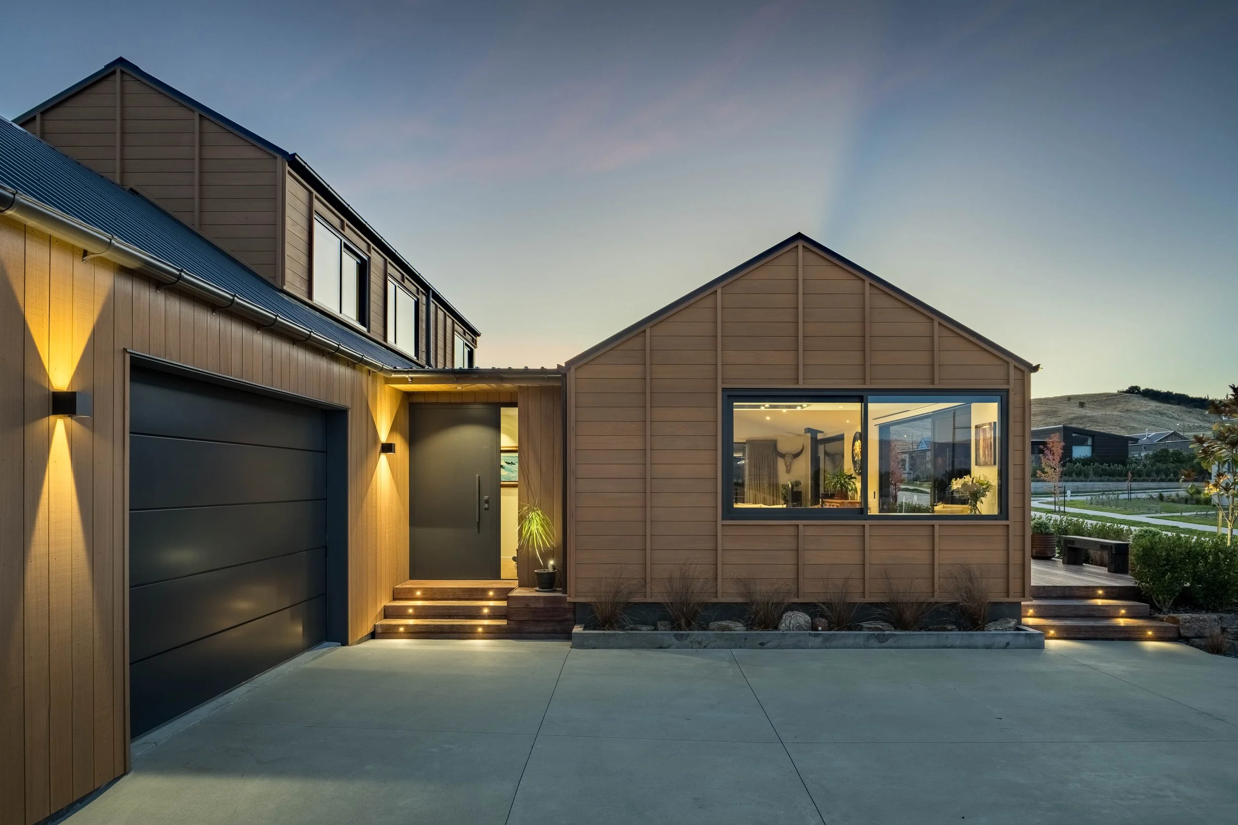 Warm exterior lighting highlights the home's contemporary alpine form at dusk.