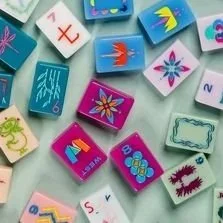 A collection of colorful plastic alphabet and number blocks with various symbols and illustrations.