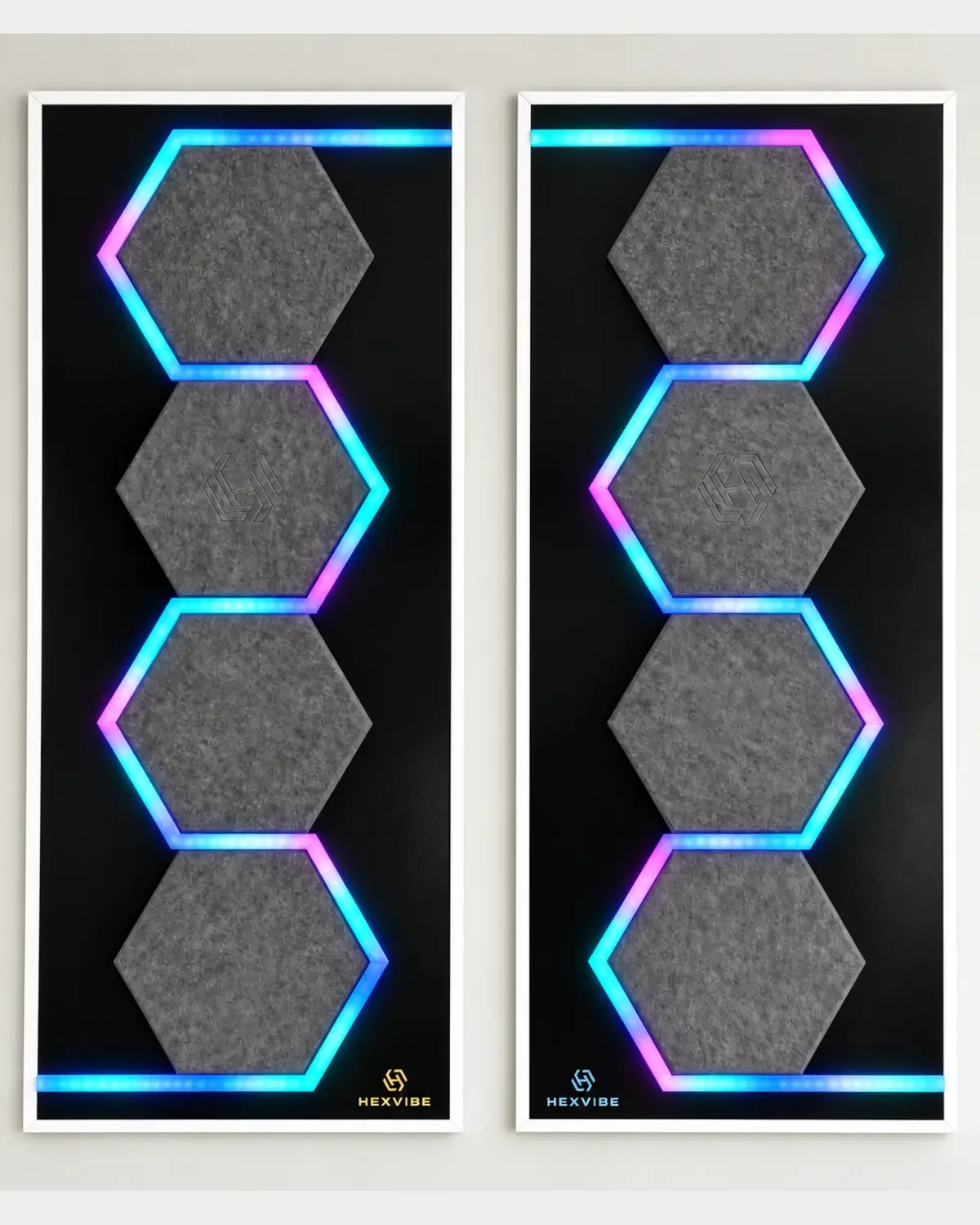 Two illuminated HexVIBE FLOW Graphite sound-reactive LED acoustic wall panels arranged as a mirrored pair with blue, cyan and magenta lighting