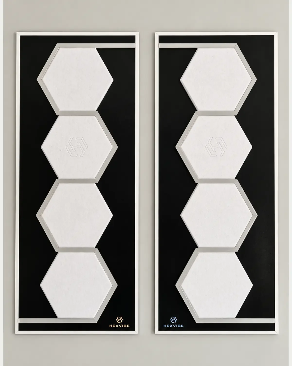 Two unlit HexVIBE FLOW Polar sound-reactive LED acoustic wall panels arranged as a mirrored pair, each featuring four white hexagons