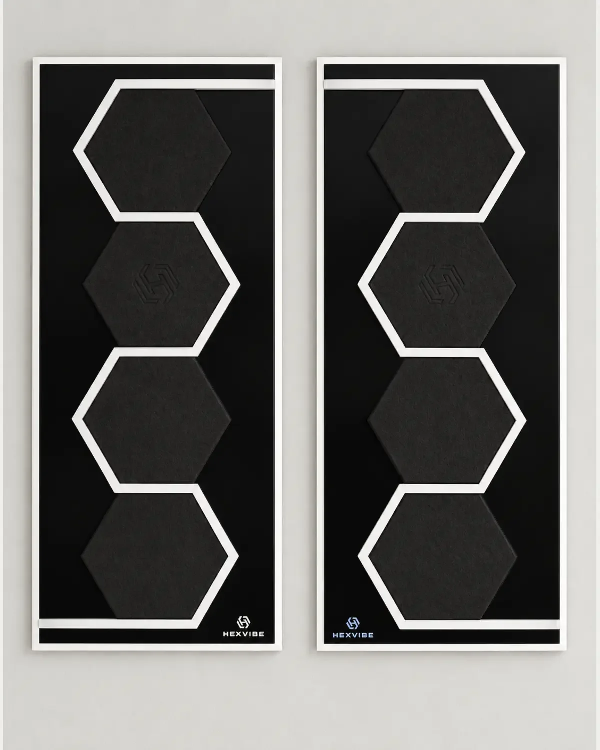 Two unlit HexVIBE FLOW Eclipse sound-reactive LED acoustic wall panels arranged as a mirrored pair, each featuring four black hexagons