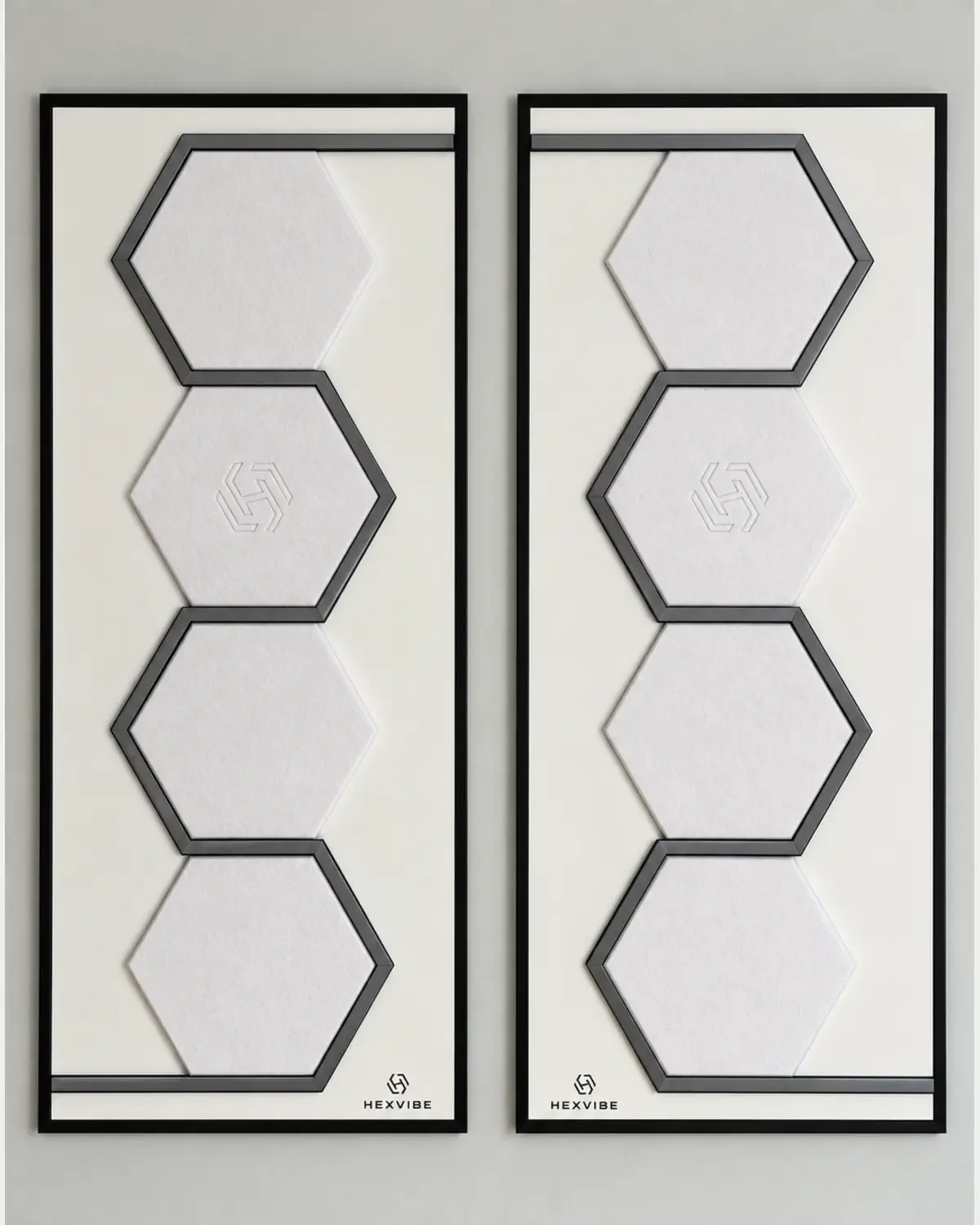 Two unlit HexVIBE FLOW Arctic sound-reactive LED acoustic wall panels arranged as a mirrored pair, each featuring four white hexagons
