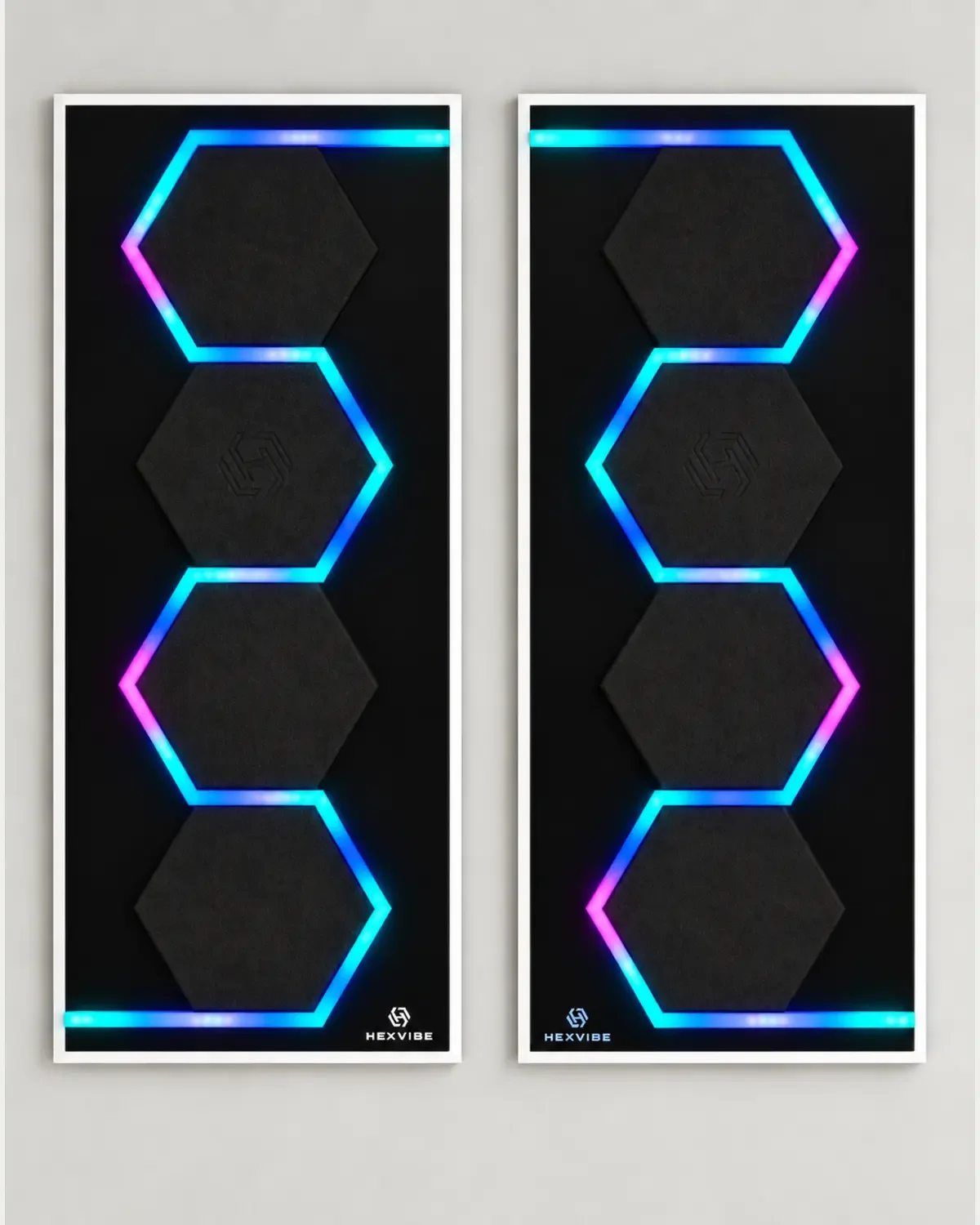 Two illuminated HexVIBE FLOW Eclipse sound-reactive LED acoustic wall panels arranged as a mirrored pair with black hexagons and blue, cyan and magenta lighting