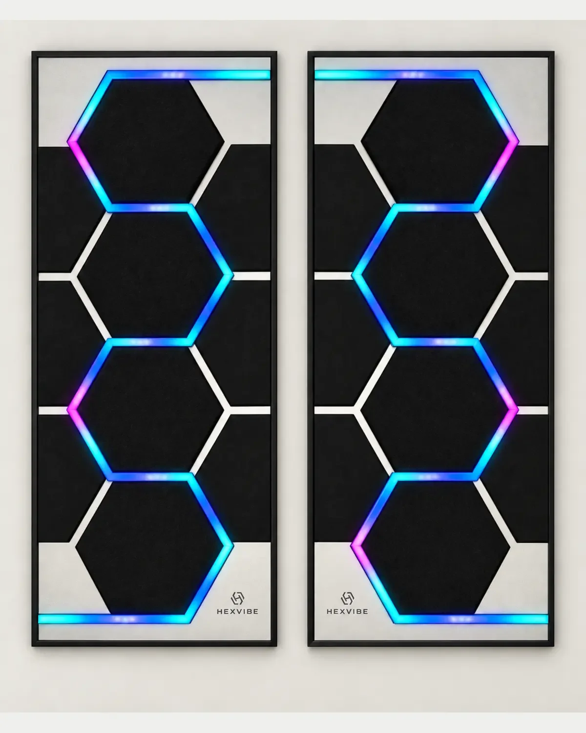 Two illuminated HexVIBE FLOW Titanium sound-reactive LED acoustic panels displaying blue, cyan and magenta lighting
