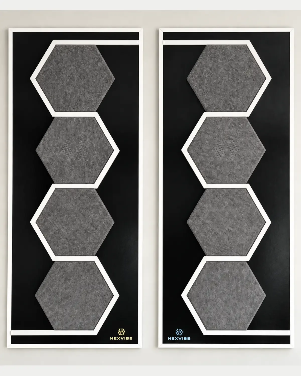 Two unlit HexVIBE FLOW Graphite sound-reactive LED acoustic wall panels arranged as a mirrored pair, each featuring four hexagons