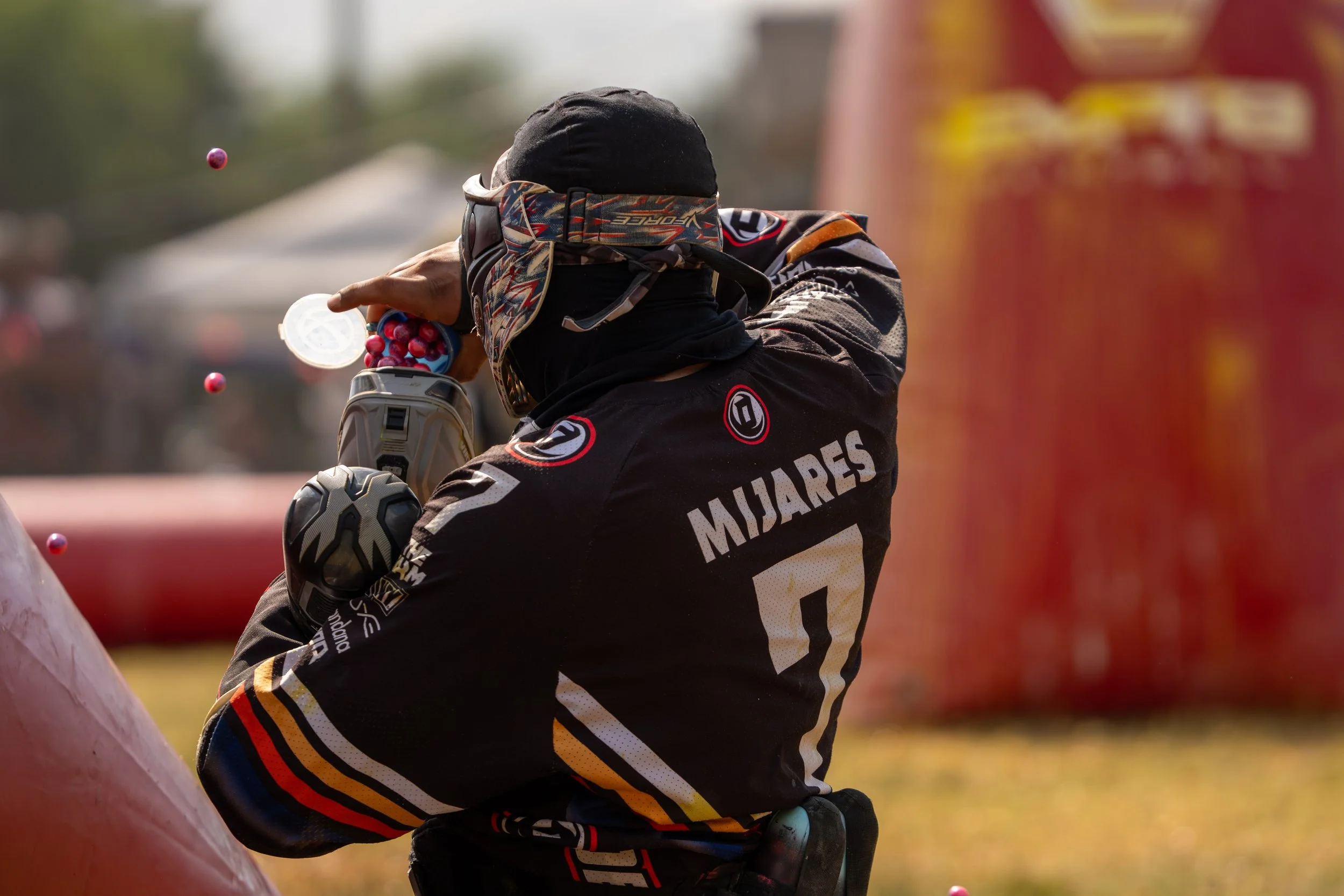 Paintball player reloading during a intense battle.