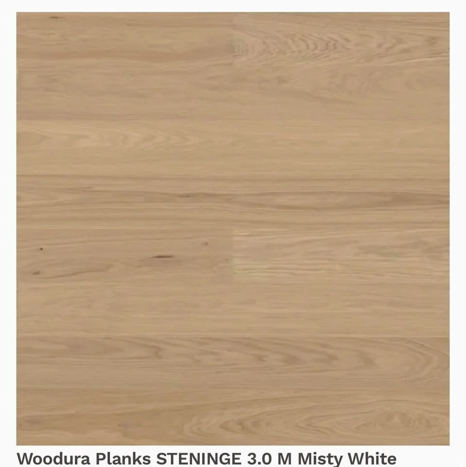 A light-colored wood laminate flooring sample labeled 'Woodura Planks STENINGE 3.0 M Misty White'.