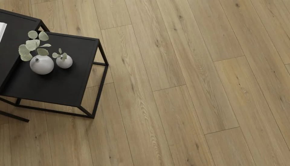 A black side table with three white vases holding eucalyptus branches on top, set on a light wood floor.