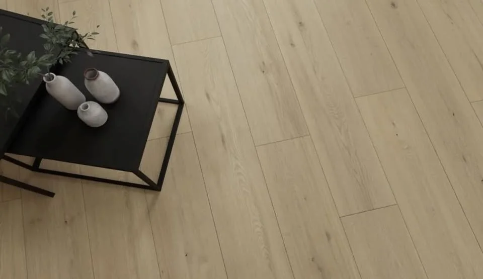 A black table with three white vases placed on top, positioned on a light-colored wooden floor.
