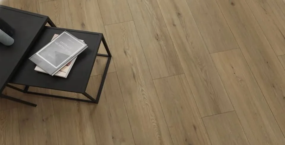 Black metal side table with a stack of magazines on a wooden floor.