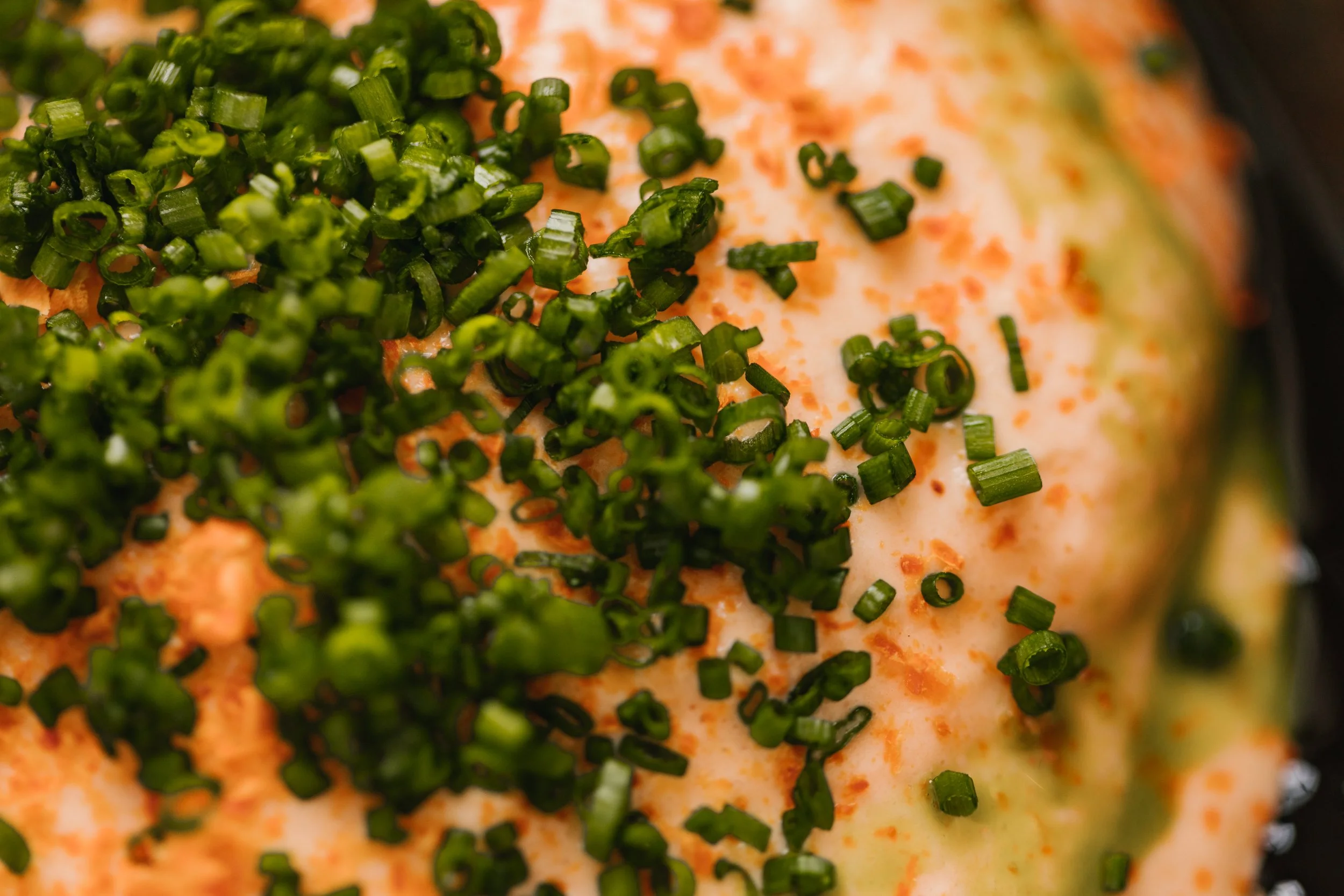 close up of a scallop roe taramasalata dish topped with finely diced chives