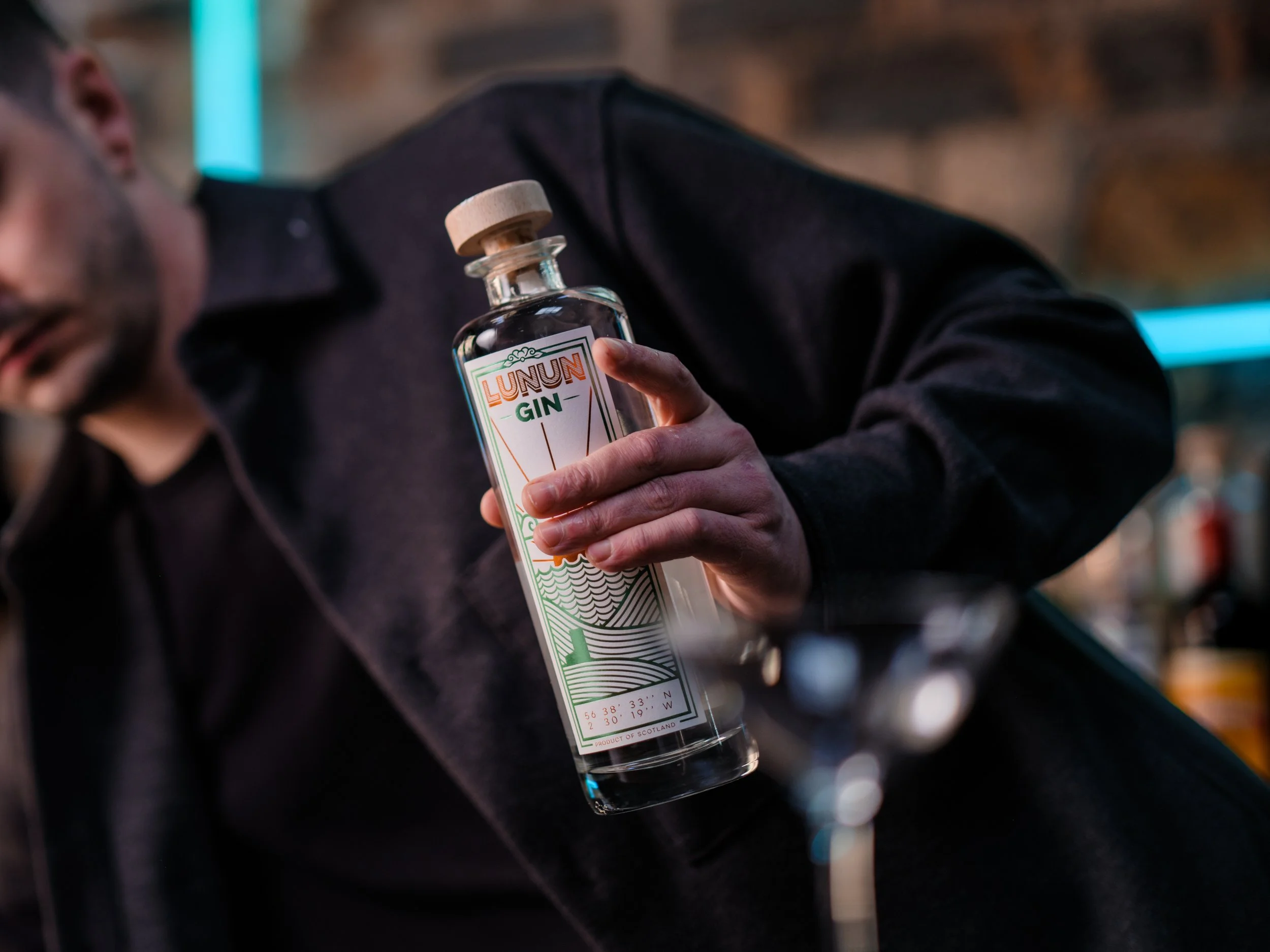 bartender holding a bottle of Lunun Gin