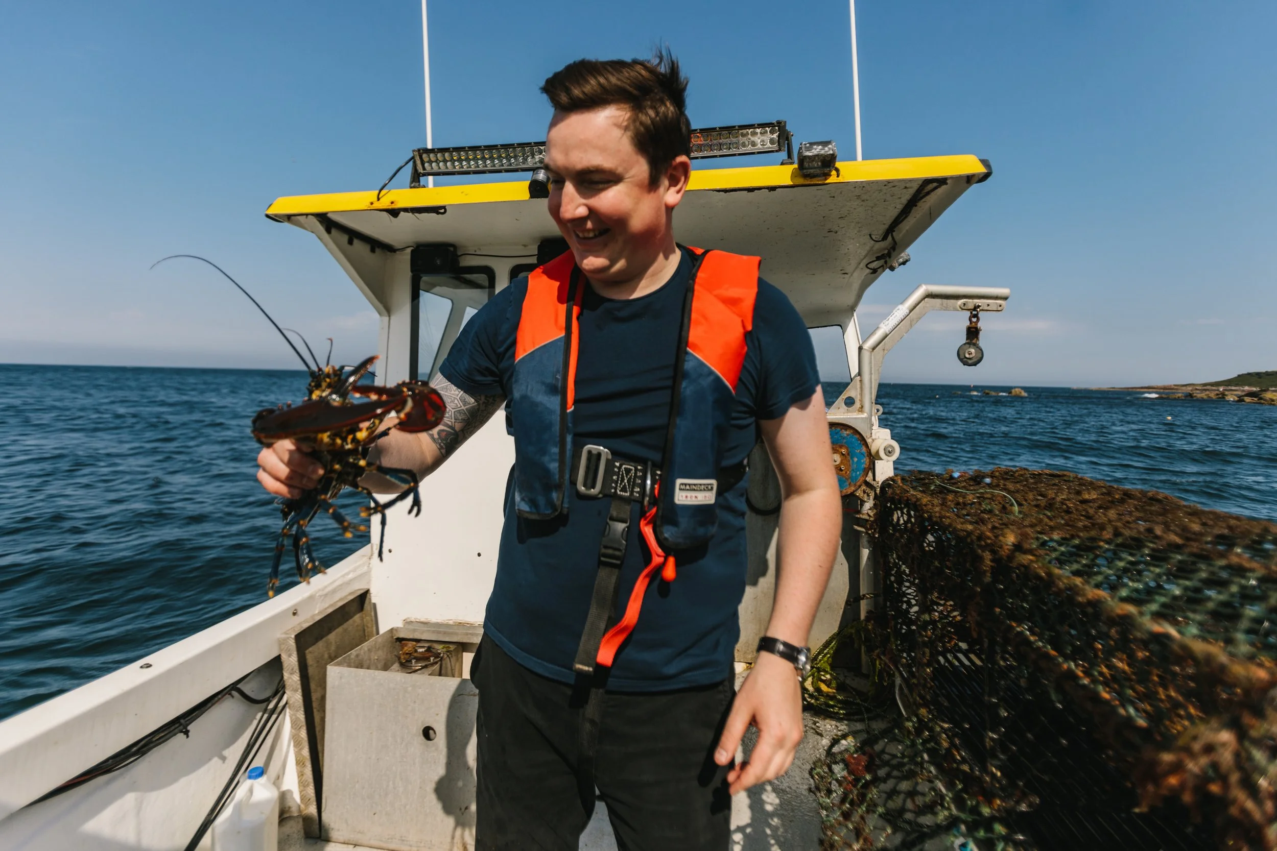 Chef Dean Banks with a lobster on a boat in St. Andrews Bay