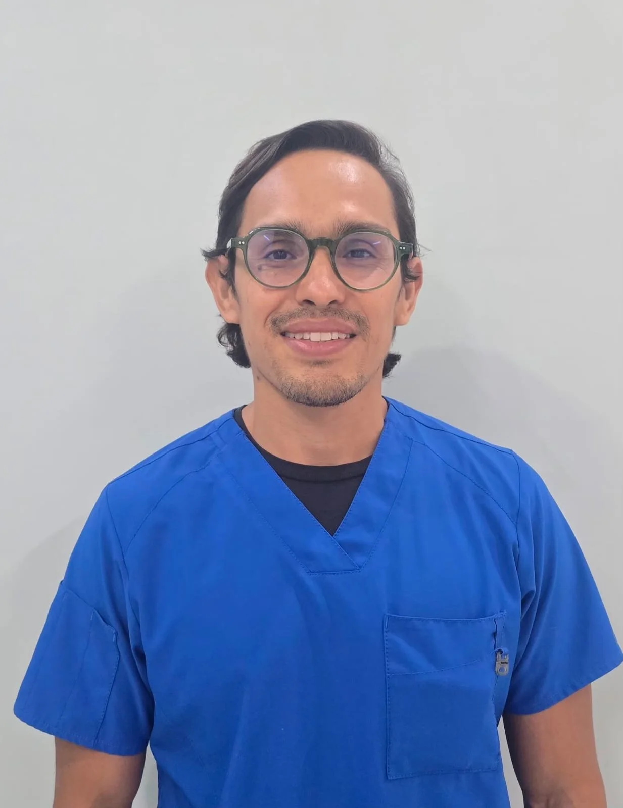 Dental Playa dentist in Playa del Carmen wearing blue medical scrubs.