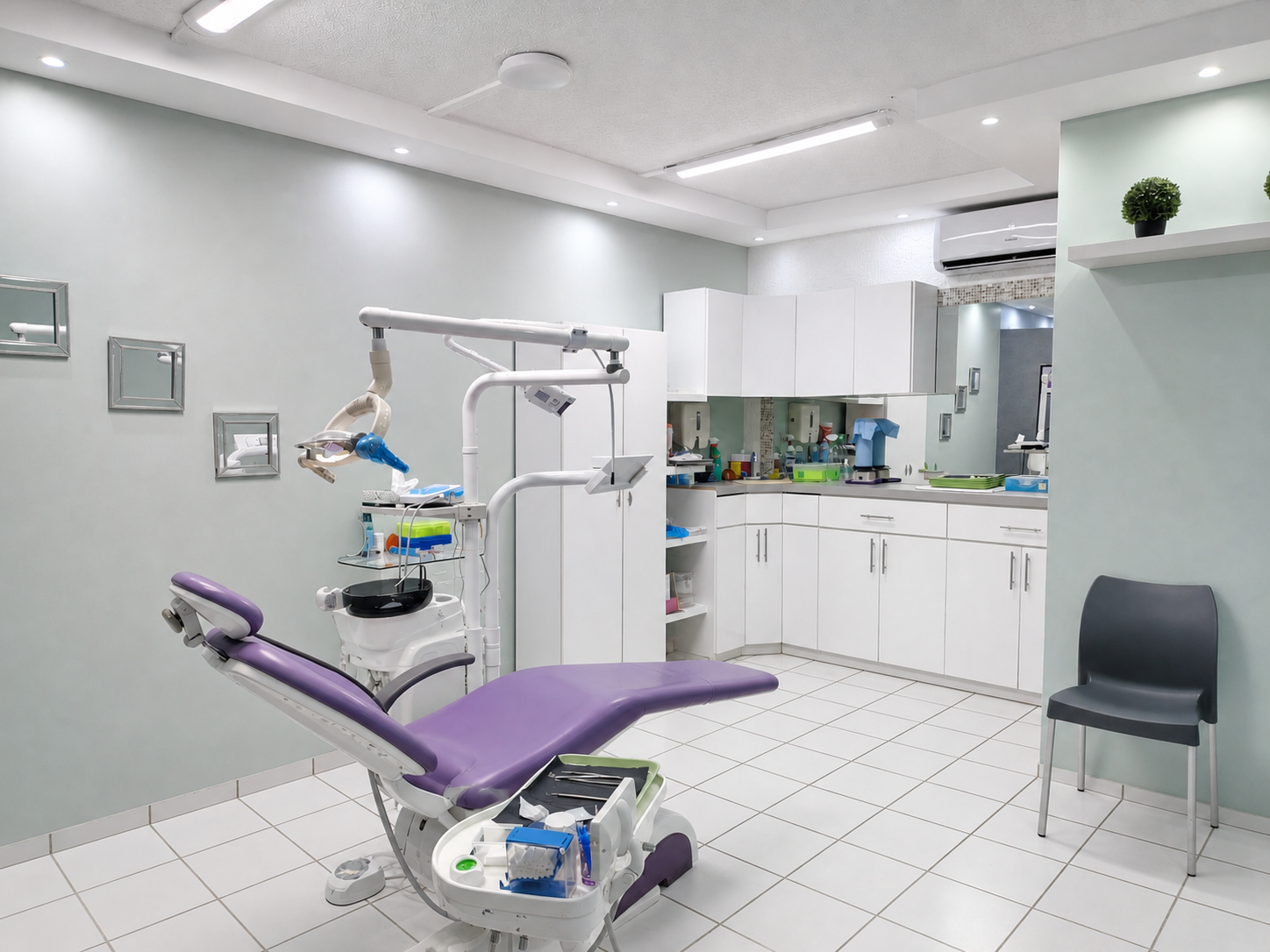 Dental examination room with dental chair, tools, and cabinets.