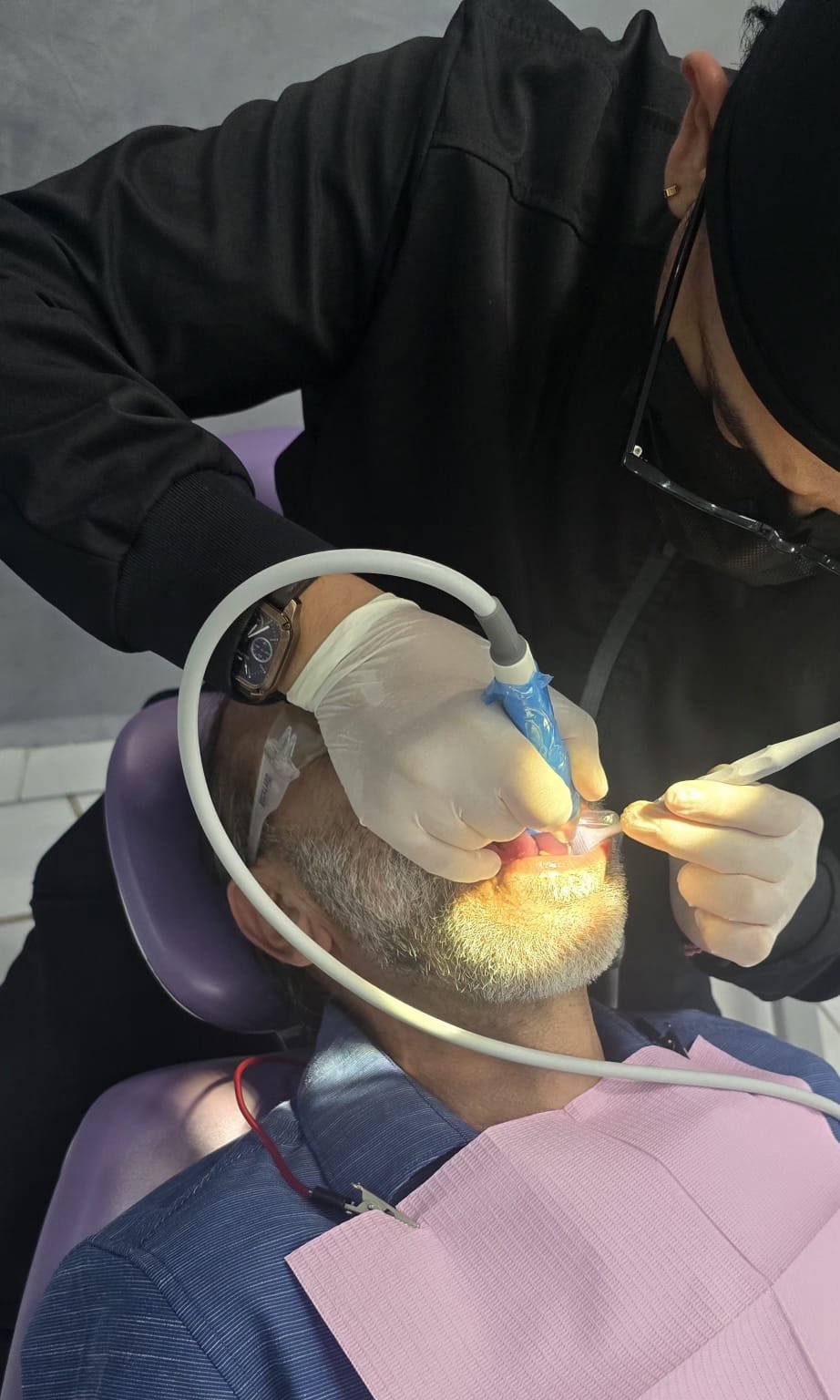 Dental Playa dentist performing a dental procedure on an elderly patient.