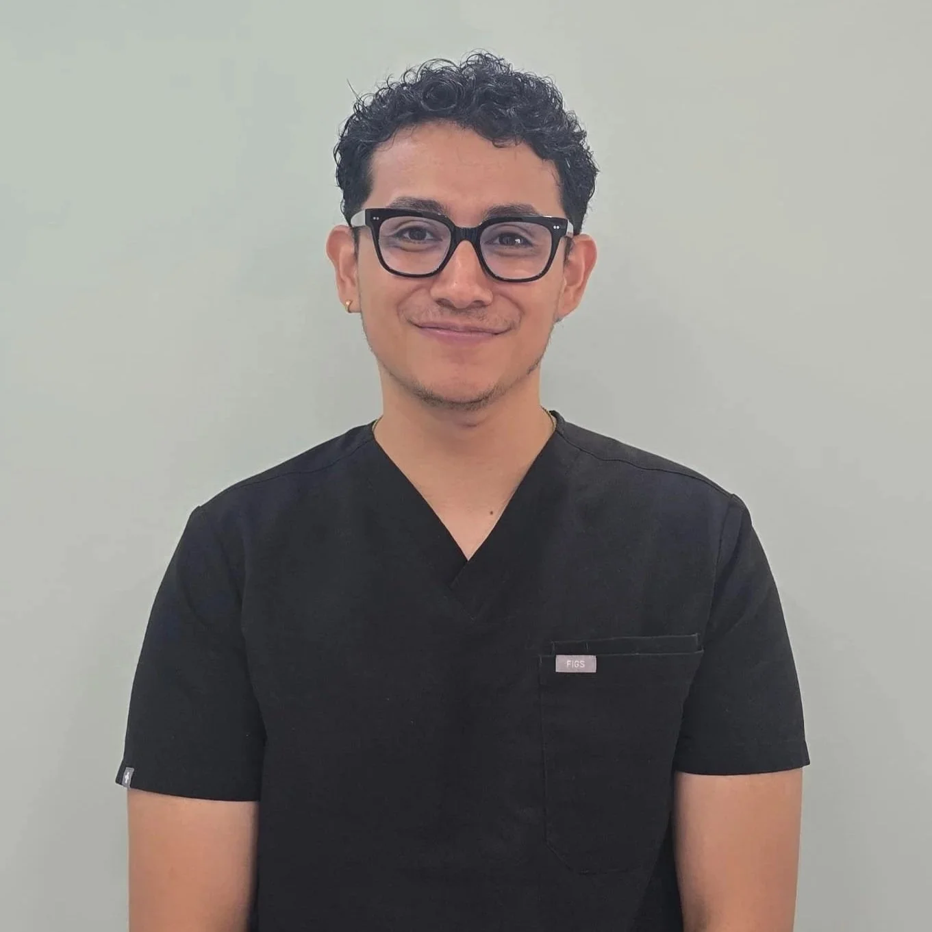 Dental Playa dentist in Playa del Carmen wearing black medical scrubs.