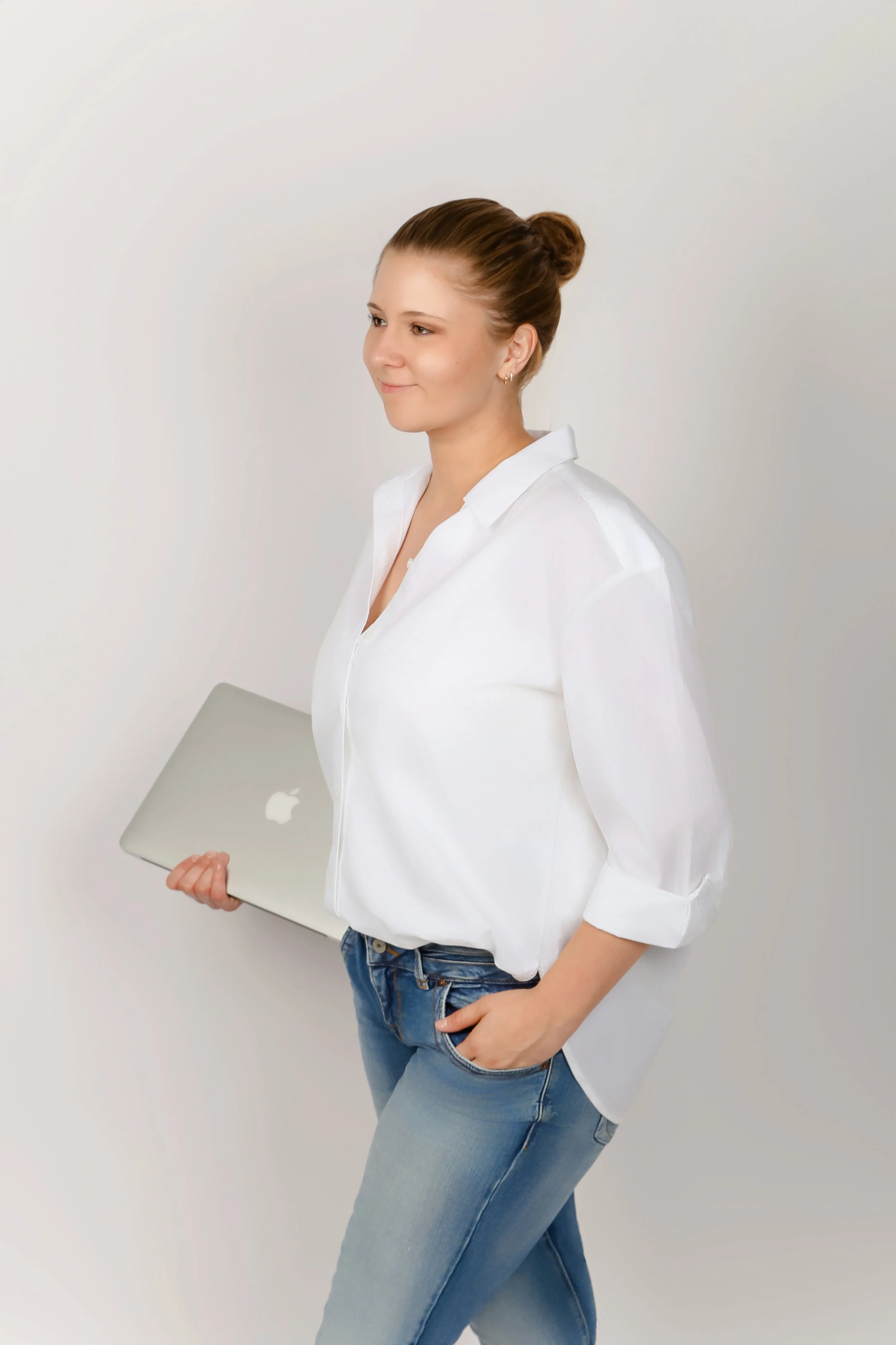 Junge Frau im weißen Hemd und blauen Jeans hält einen Laptop in der Hand Antonia Werner, Emotion Code, Identität, Blockaden Emotionen, Selbstwert, Selbstliebe. Selbstwert, Emotion Code Anwenderin Deutschland. Practitioner, Antonia Werner