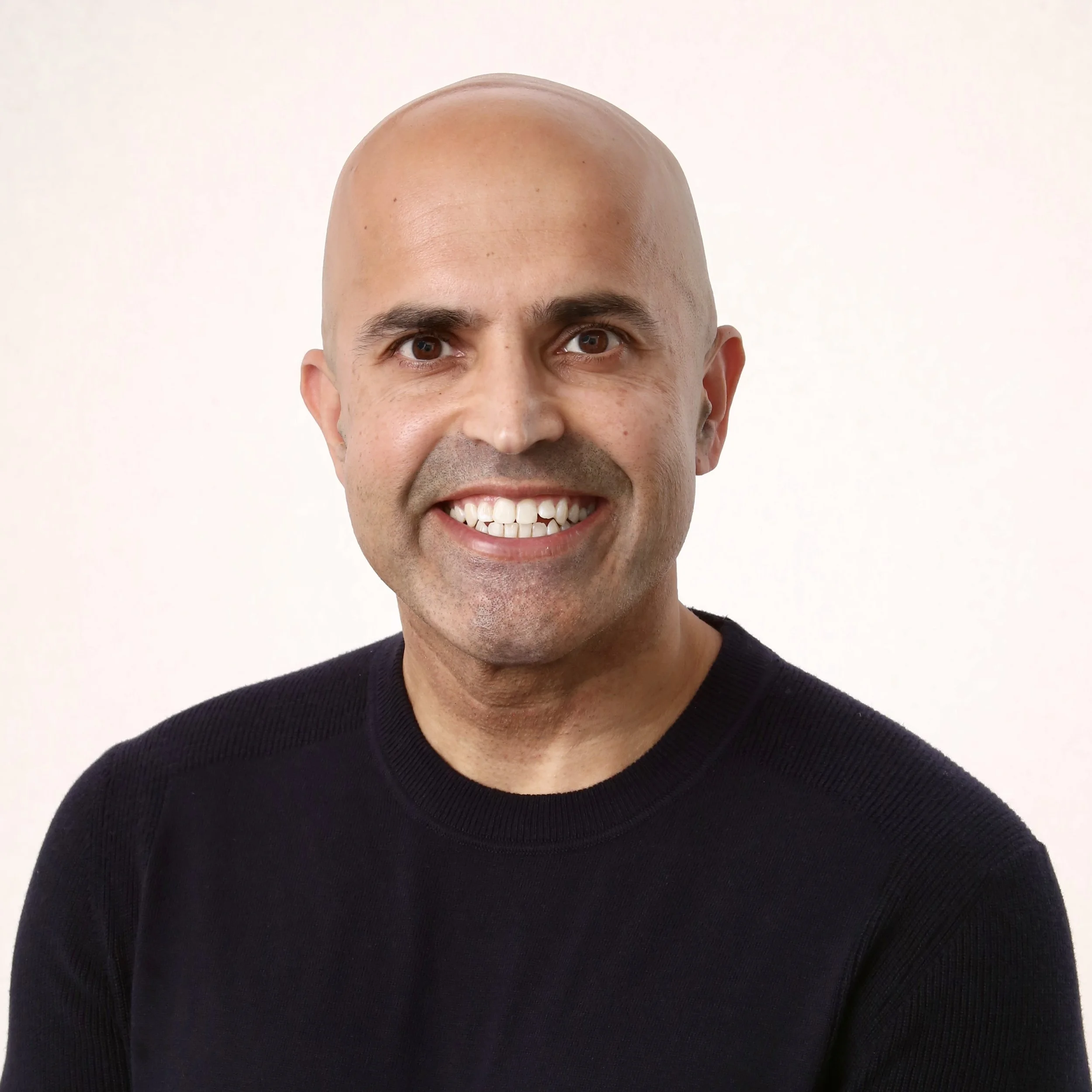 Close-up of PRAN Holdings Founder, Niten Kapadia, wearing a black sweater, against a plain white background.