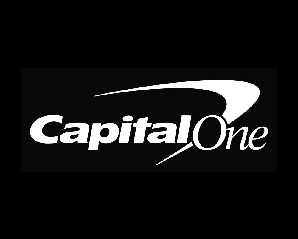Capital One logo with black background, white stylized text, and a swoosh design.