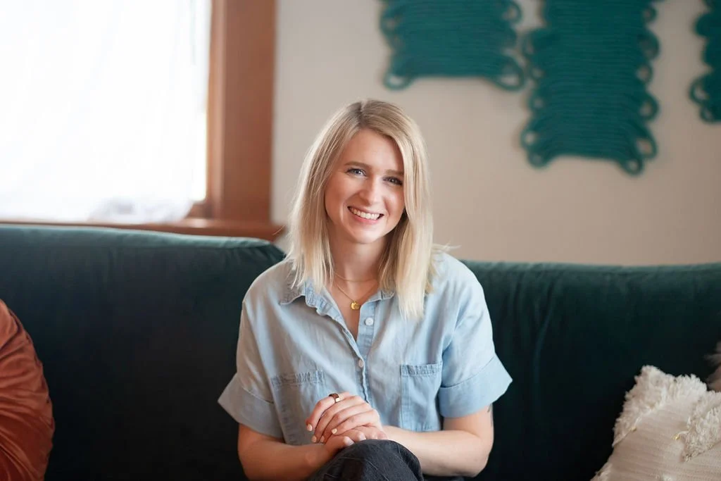 Therapist smiling sitting on a green couch
