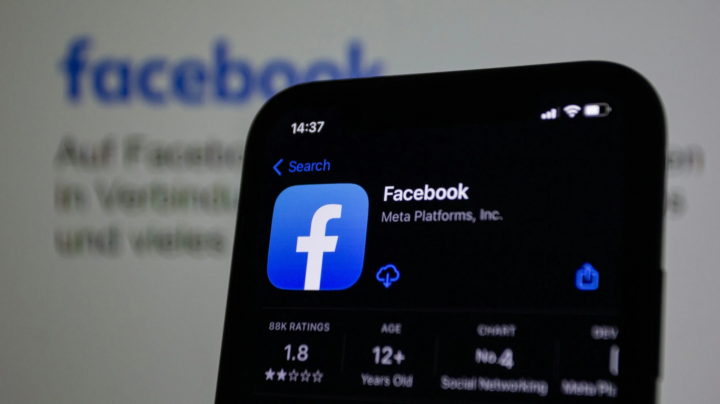 A smartphone screen displays the Facebook app page with the Facebook logo, app name, developer, user ratings, age restriction, and other details. A blurred Facebook logo is visible in the background.