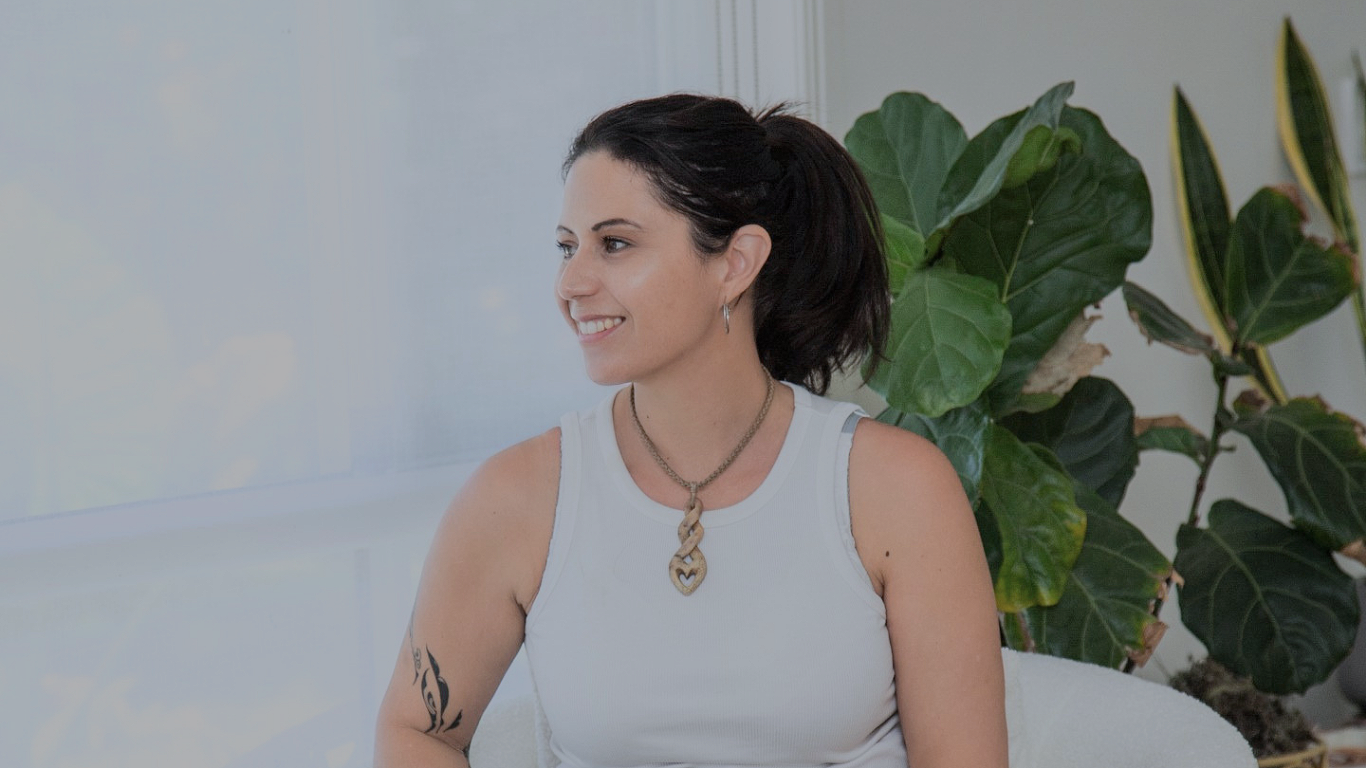 Natalie Seigne sitting on a sofa in a calm space, spiritual healer and intuitive guide offering energy healing, mediumship and life direction support for clients seeking clarity, emotional healing and grounded spiritual guidance.