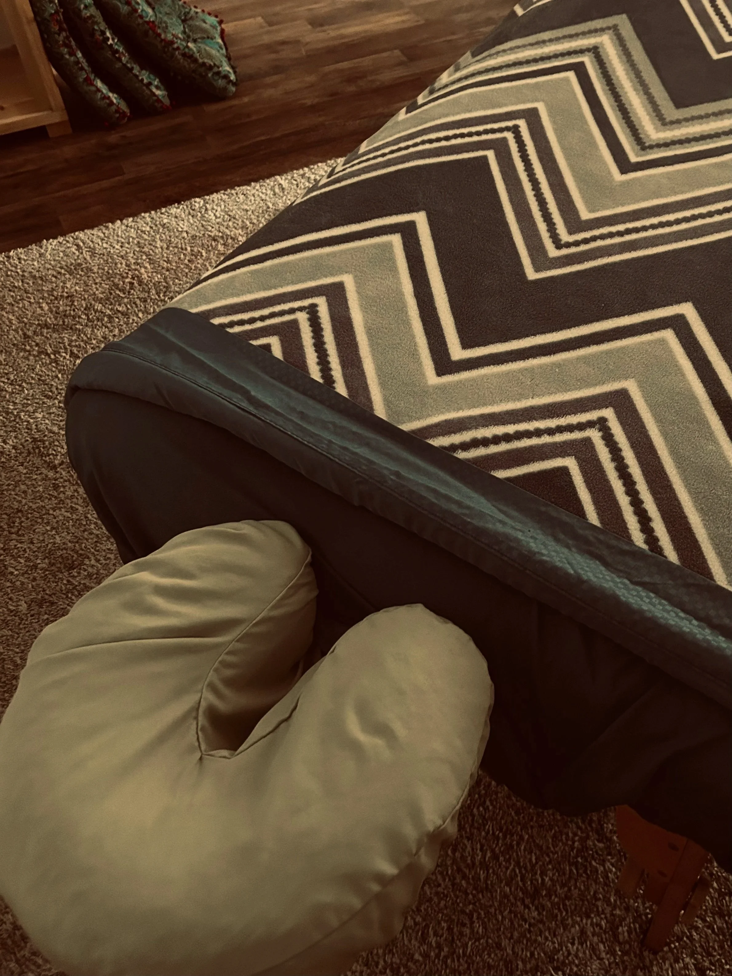Close-up of a face cradle and a massage table with soft blanket and soothing colors