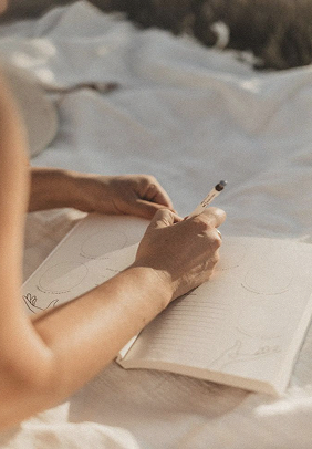 A woman writing in a journal during a guided reflection practice.