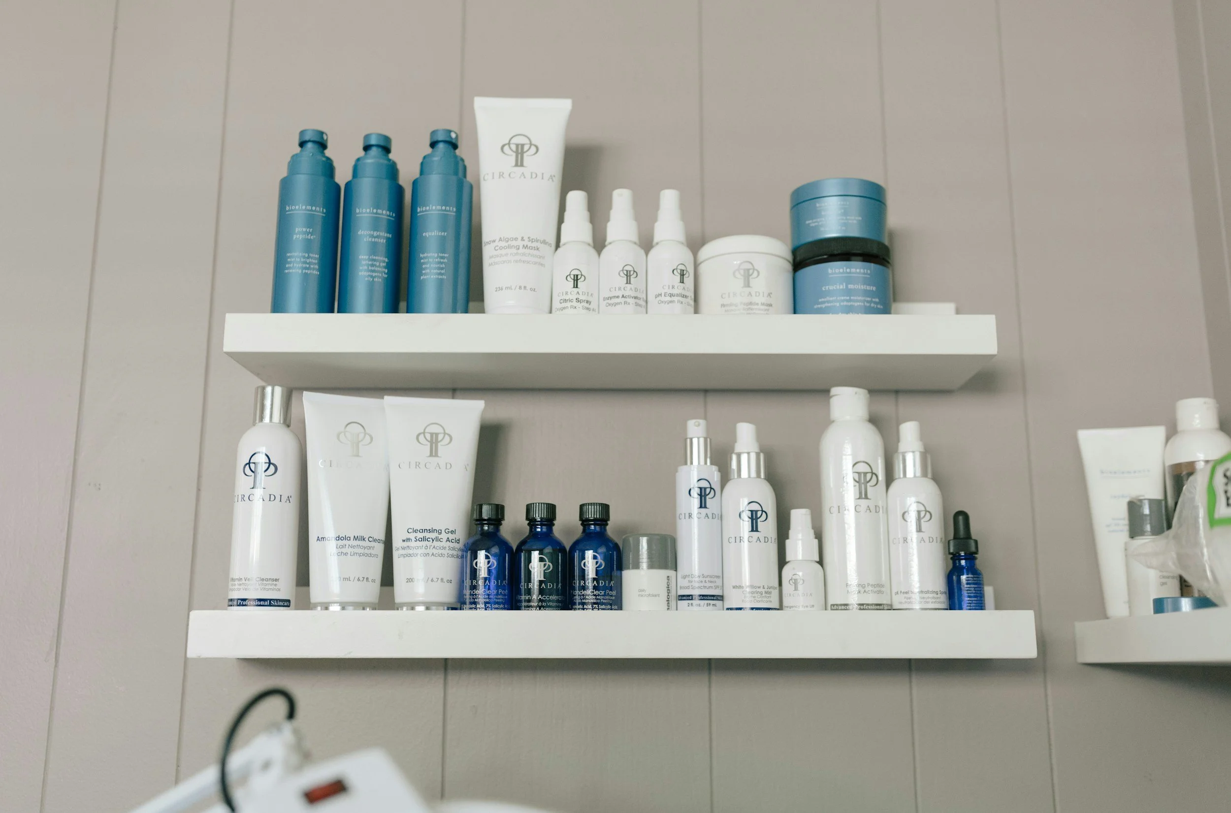 White shelves filled with various skincare products in blue and white containers in a spa setting.