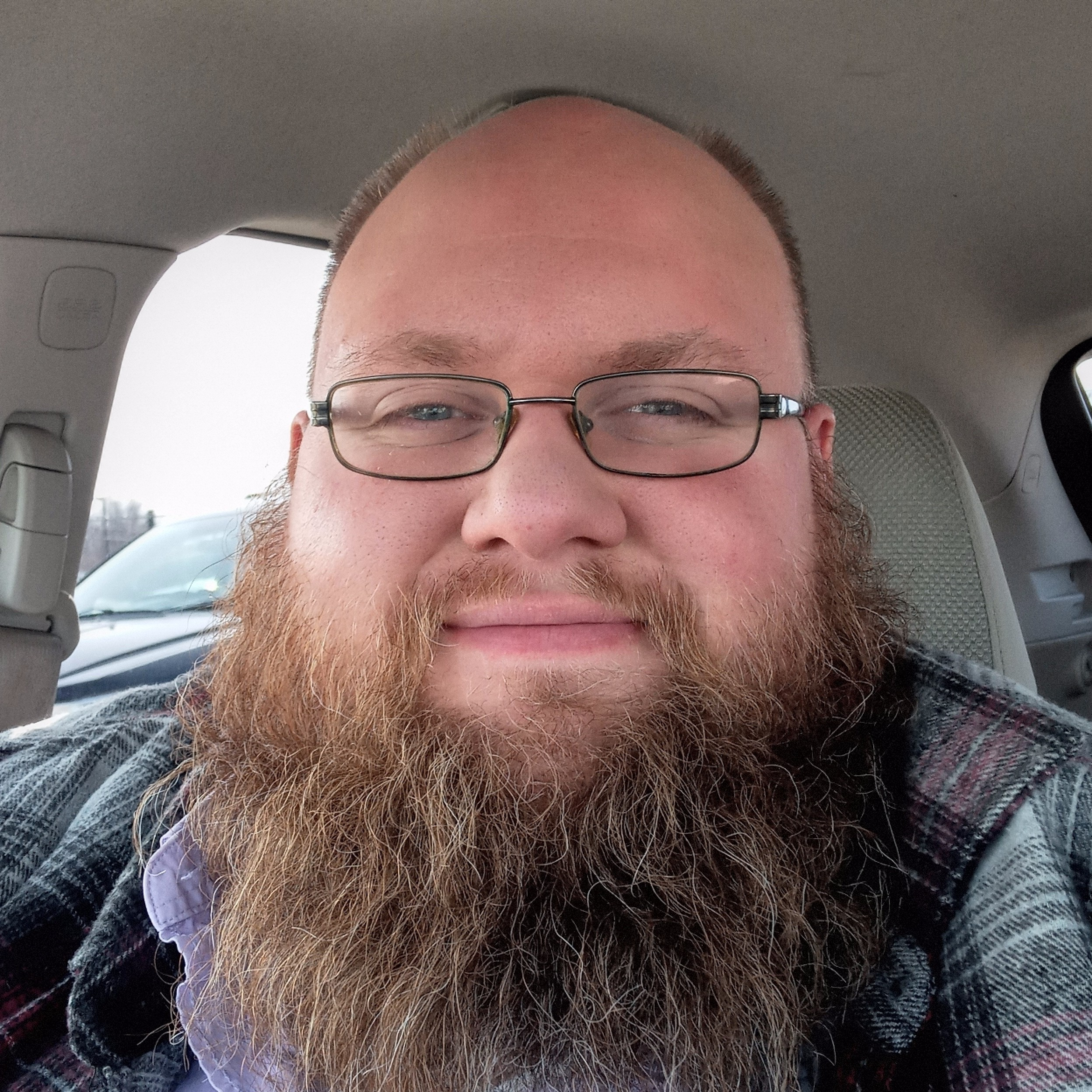 Close-up of a person's forehead and glasses inside a vehicle, with the background showing the vehicle's interior.