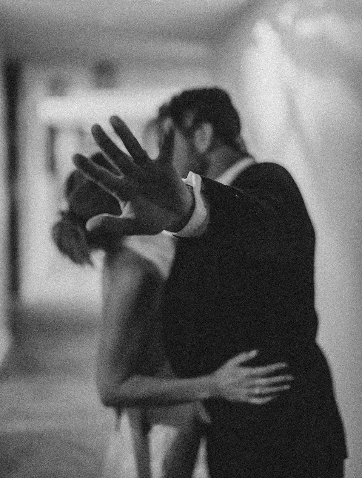 Groom kissing the bride's hand in their hotel room.jpg