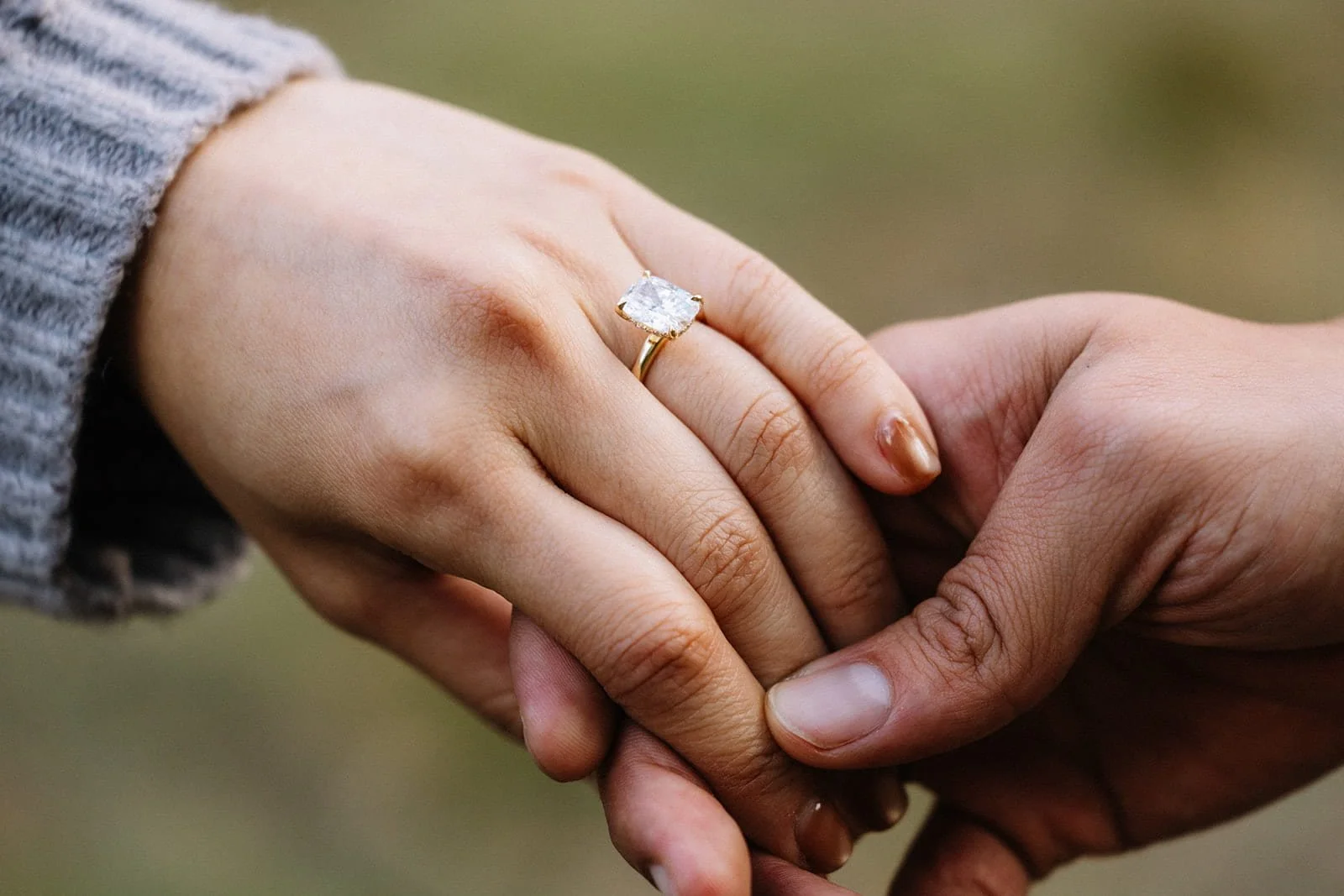 Close-up of a couple holding hands in Cathedral Meadow, Yosemite, showing off her engagement ring