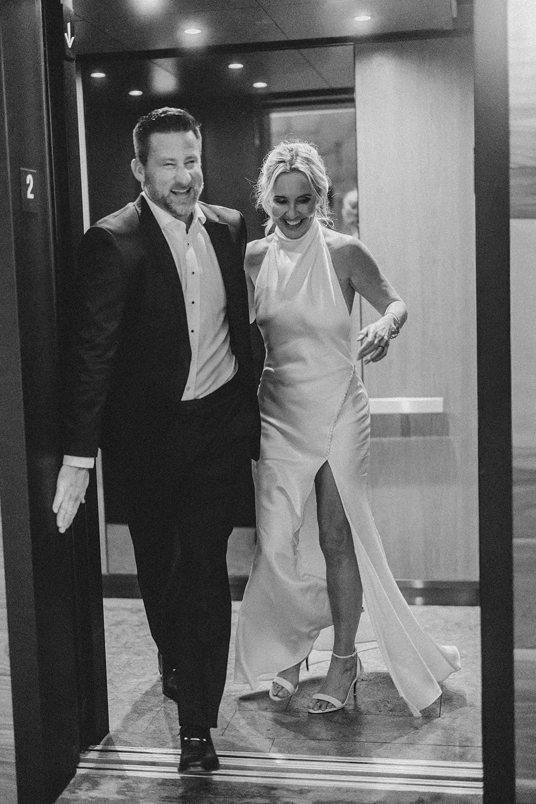bride and groom laughing coming out of elevator.jpg