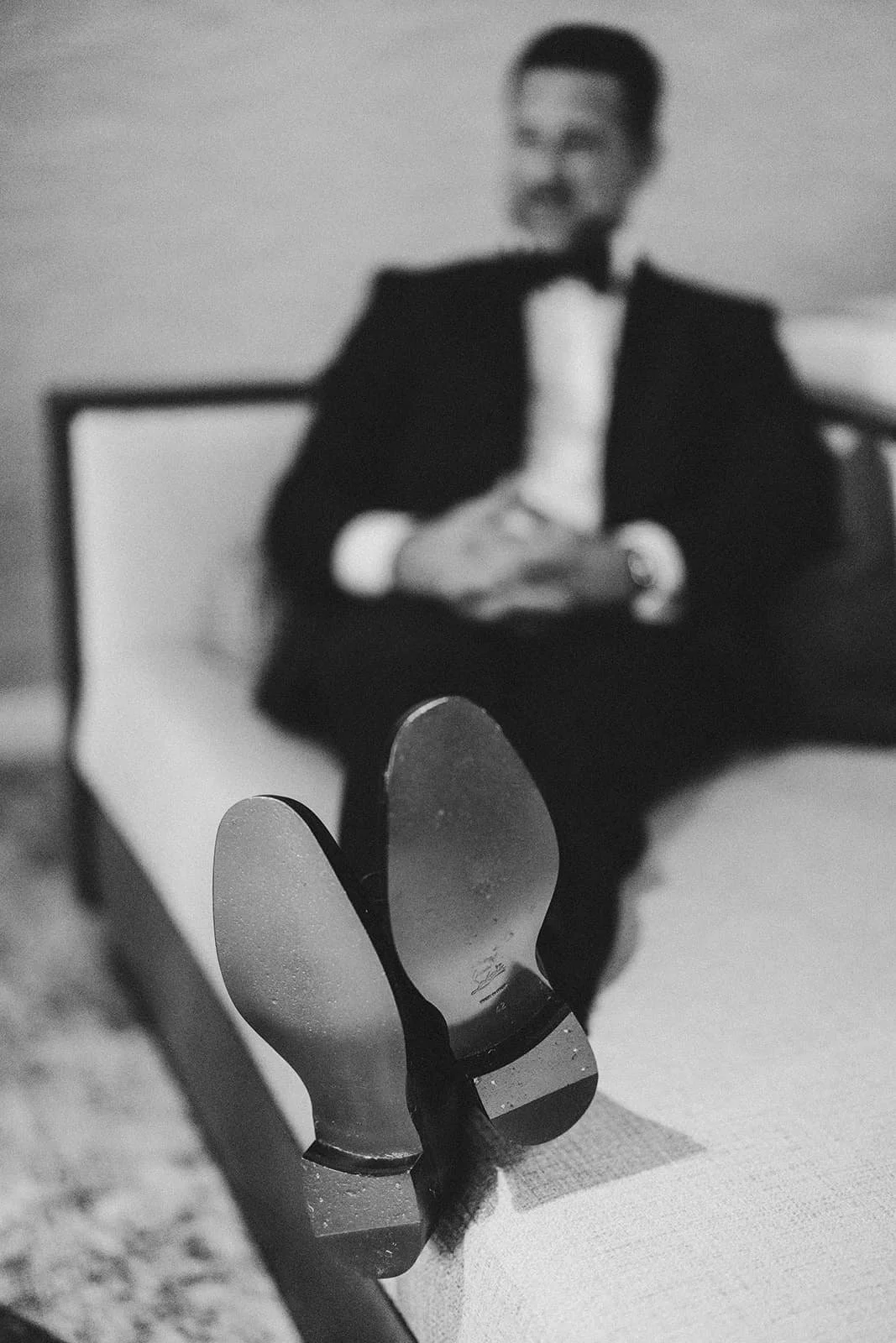 Groom relaxing on a hotel bed before his Lake Tahoe elopement.jpg