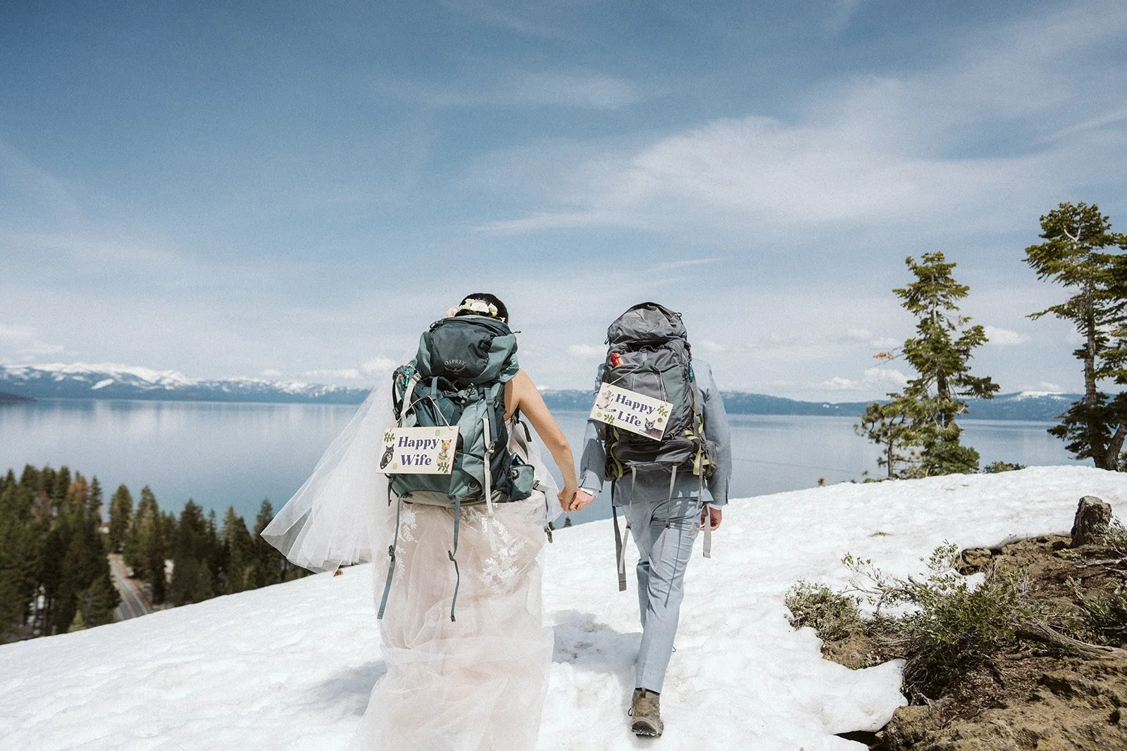 Bride and groom hiking snowy trail to Eagle Rock elopement, Lake Tahoe winter — AJ Photography