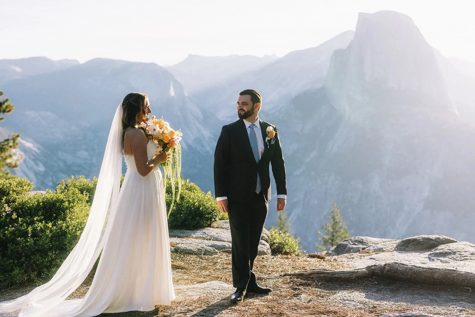 A bride and groom standing at Glacier point for their first look