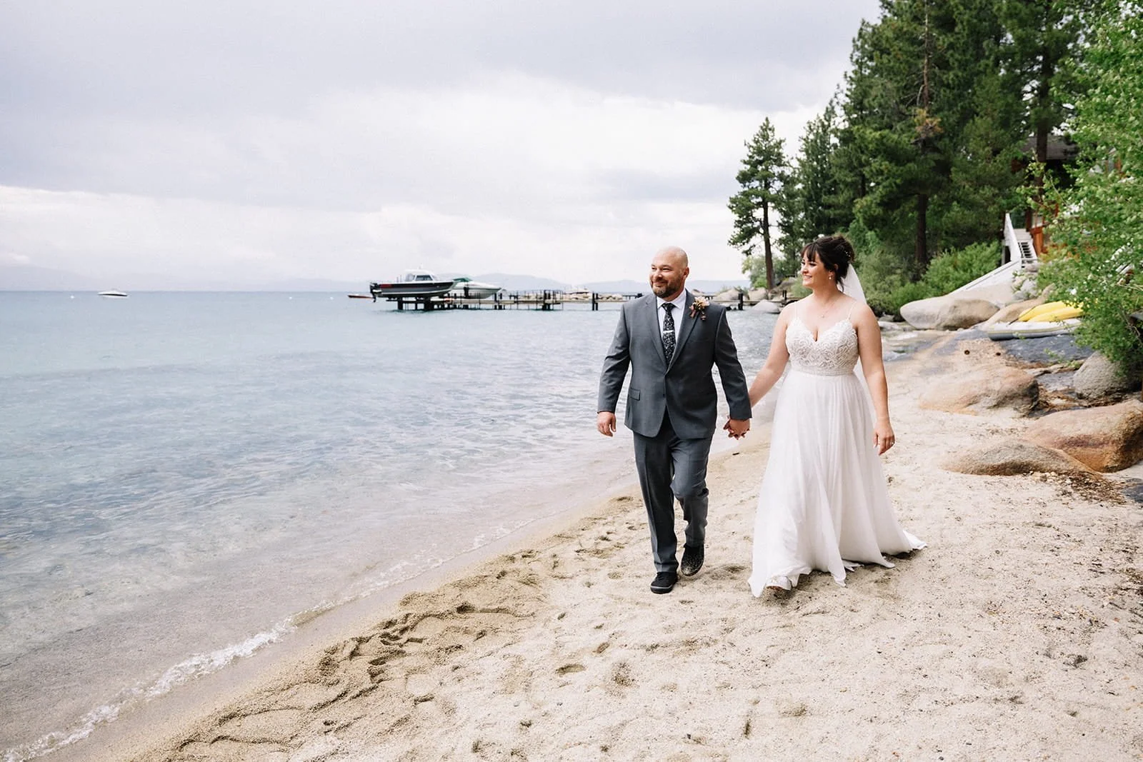 bride and groom walking on beach in lake tahoe.jpg