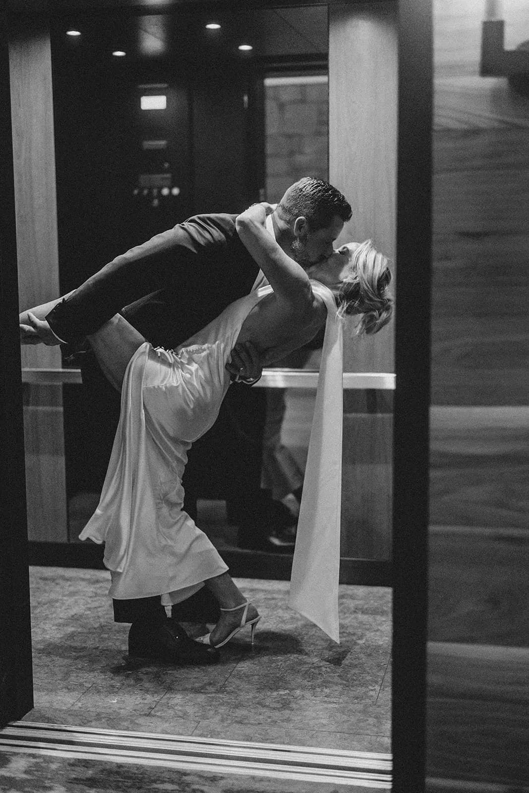 Groom dipping the bride for a kiss in black and white.jpg