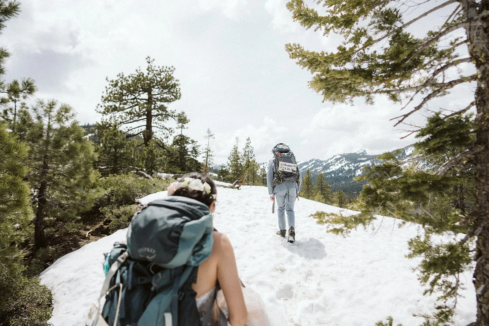 Couple hiking through snow to elopement ceremony location at Lake Tahoe in winter — AJ Photography