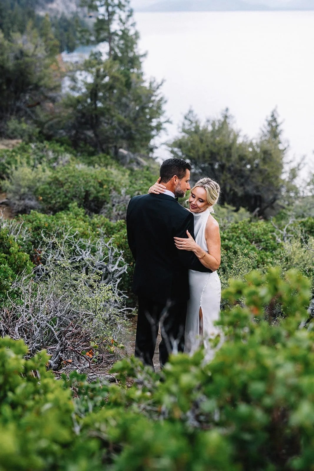 Bride and groom embracing in a forested meadow at Lake Tahoe.jpg