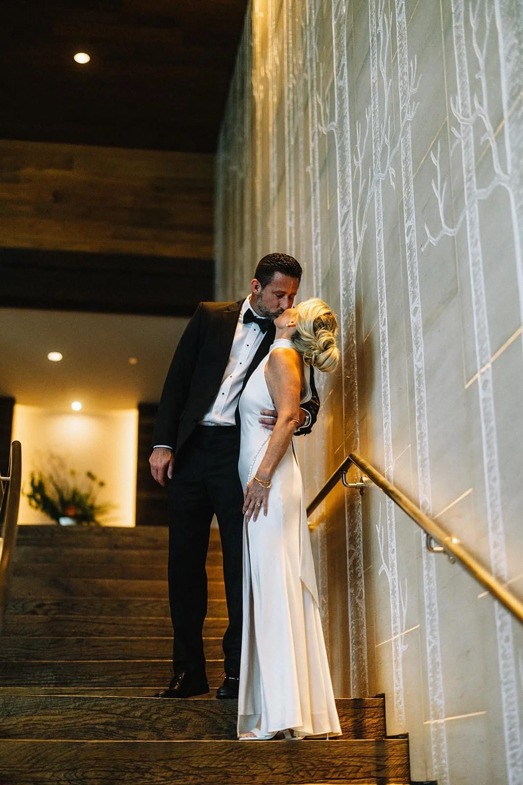 bride and groom kissing on stairway in hotel.jpg